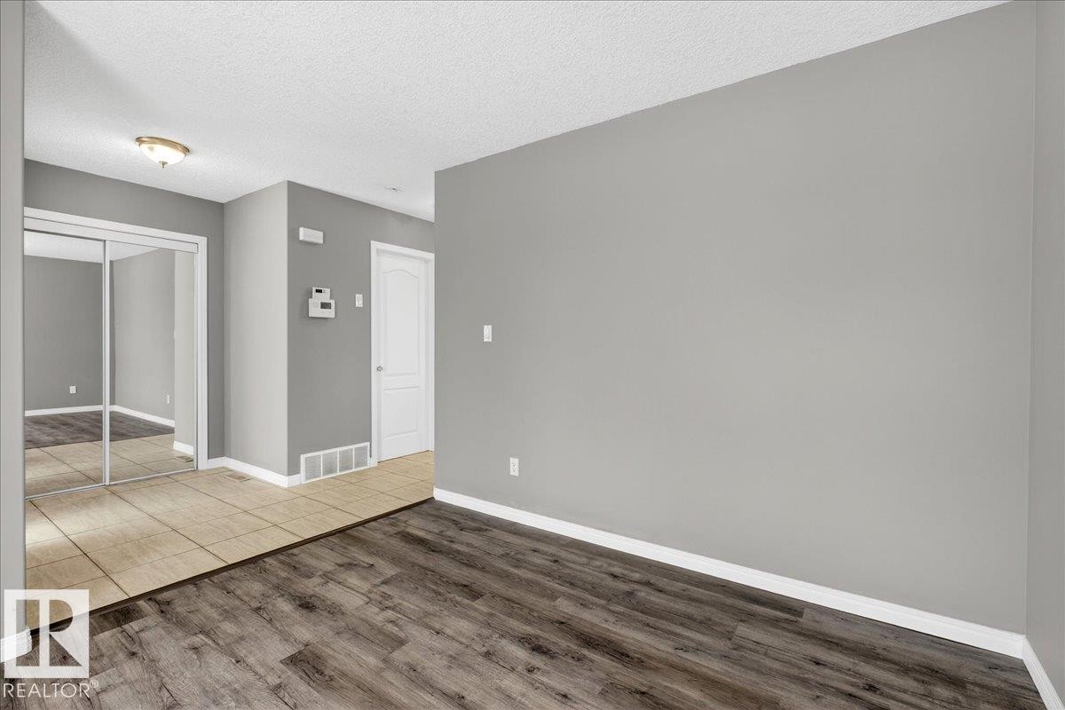 Spare room featuring a textured ceiling and wood finished floors - 150 Acacia Circle, Leduc, AB - Indoor Photo Showing Other Room