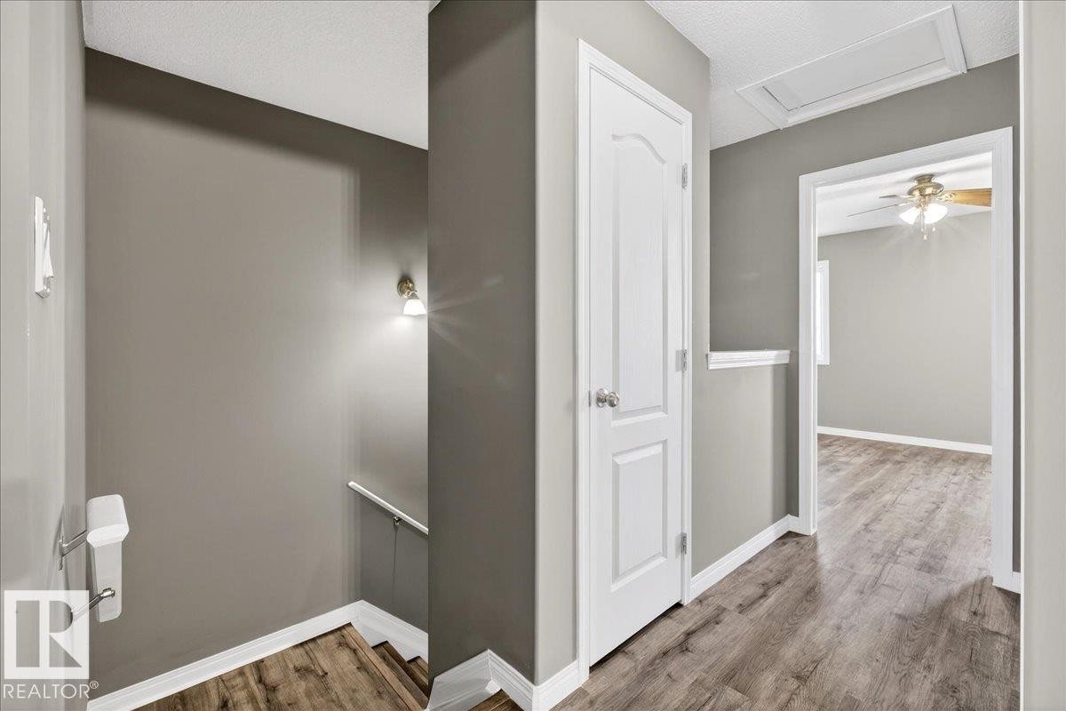 Hall featuring an upstairs landing, wood finished floors, and attic access - 150 Acacia Circle, Leduc, AB - Indoor Photo Showing Other Room