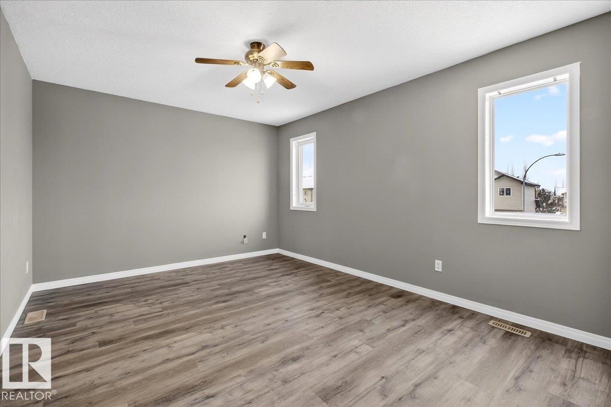 Unfurnished room featuring wood finished floors, a textured ceiling, and ceiling fan - 150 Acacia Circle, Leduc, AB - Indoor Photo Showing Other Room