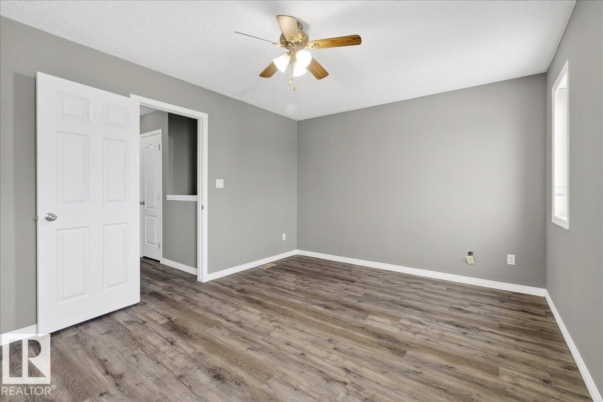 Unfurnished bedroom featuring wood finished floors, ceiling fan, and a textured ceiling - 150 Acacia Circle, Leduc, AB - Indoor Photo Showing Other Room