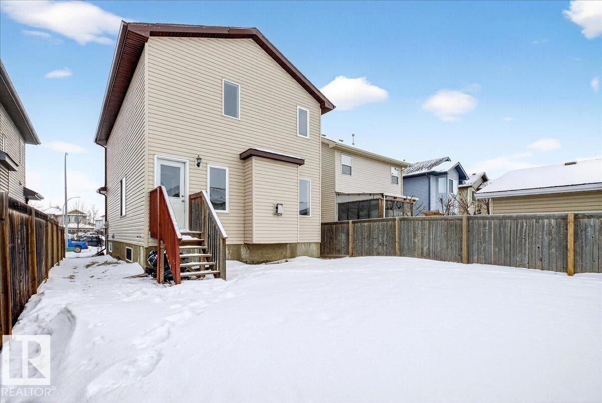 Snow covered rear of property featuring a fenced backyard - 150 Acacia Circle, Leduc, AB - Outdoor