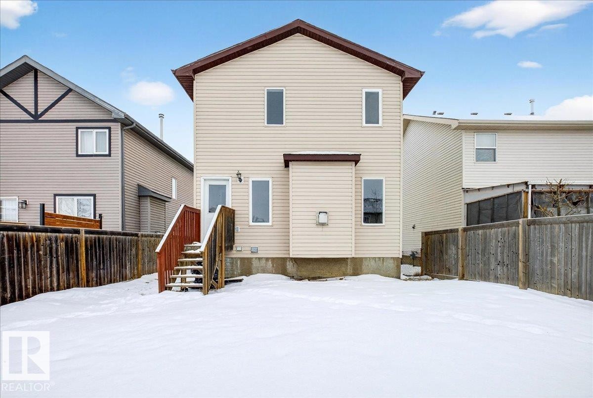Snow covered back of property with a fenced backyard - 150 Acacia Circle, Leduc, AB - Outdoor With Exterior