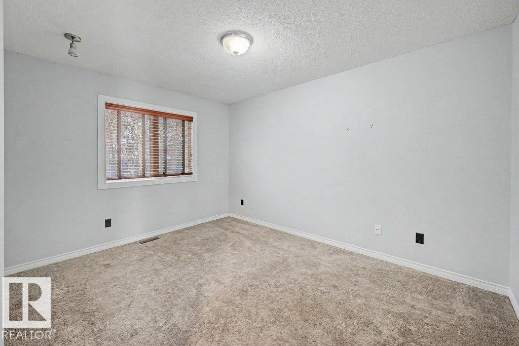 This room features light grey walls, a window with wooden blinds, and carpeted flooring - Edmonton, AB - Indoor Photo Showing Other Room