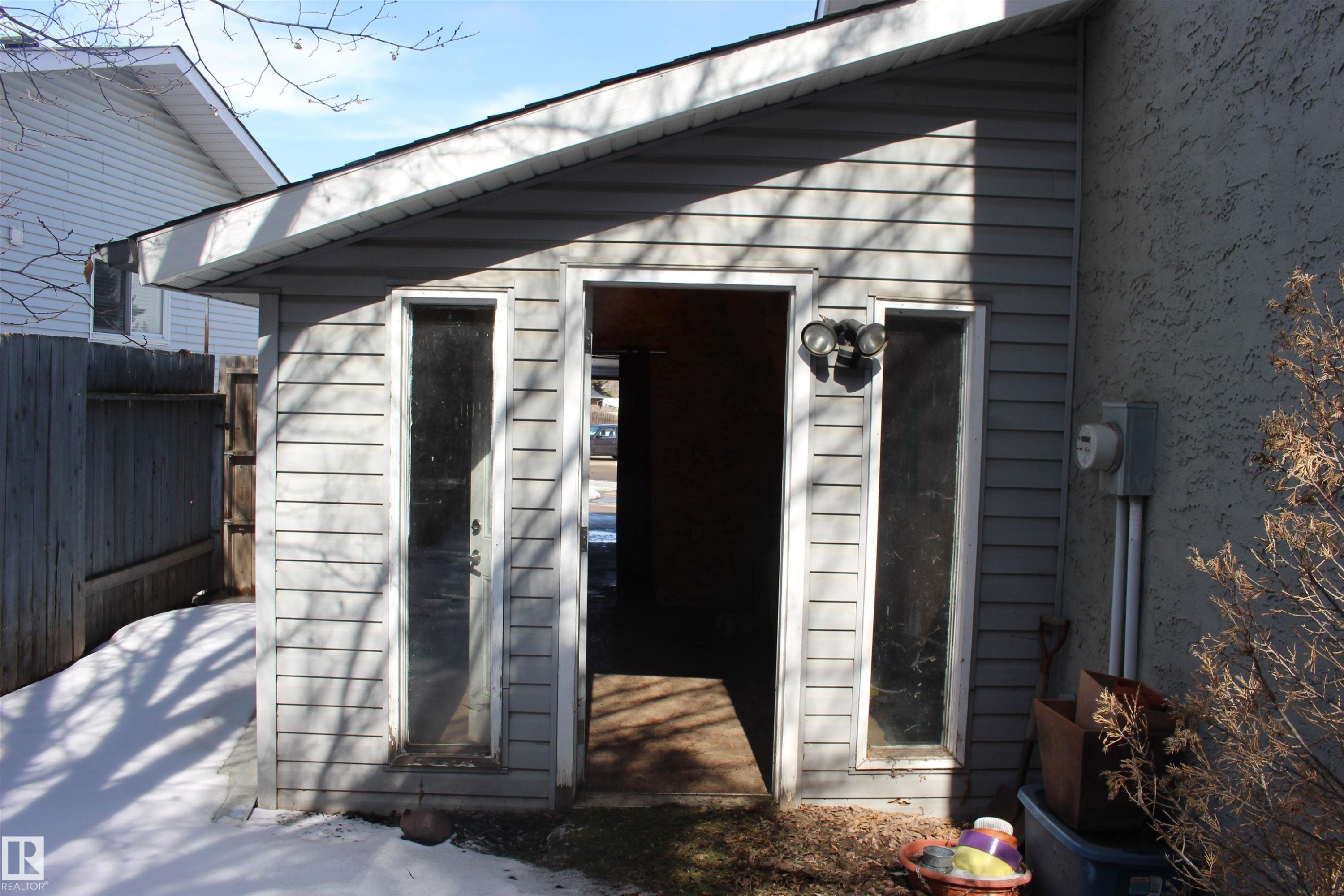 Exterior of the property featuring horizontal siding, a fenced perimeter, and an outdoor light fixture - Edmonton, AB - Outdoor