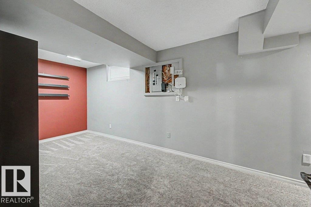 The property features a room with light grey carpeting, light grey walls, and a distinct accent wall in a red hue - Edmonton, AB - Indoor