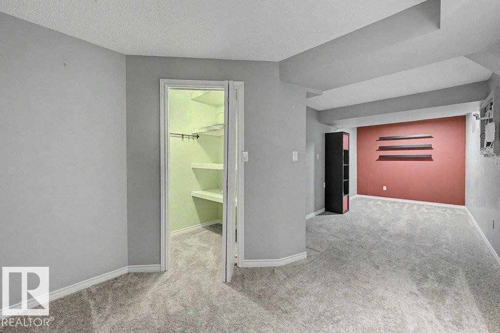 Versatile room with grey carpeting and a closet with shelving - Edmonton, AB - Indoor