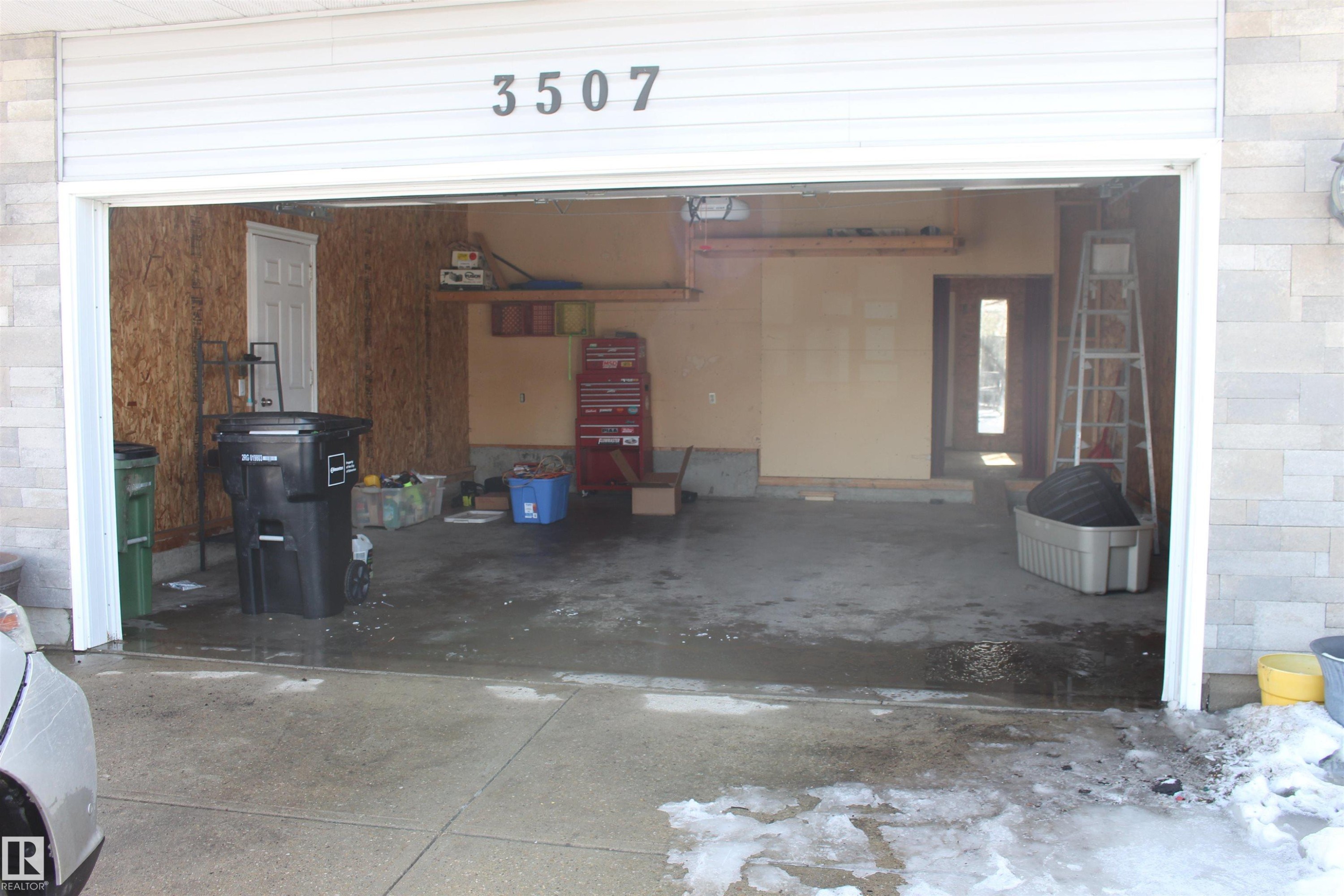 The property features an attached garage with a white garage door and concrete floor - Edmonton, AB - With Exterior