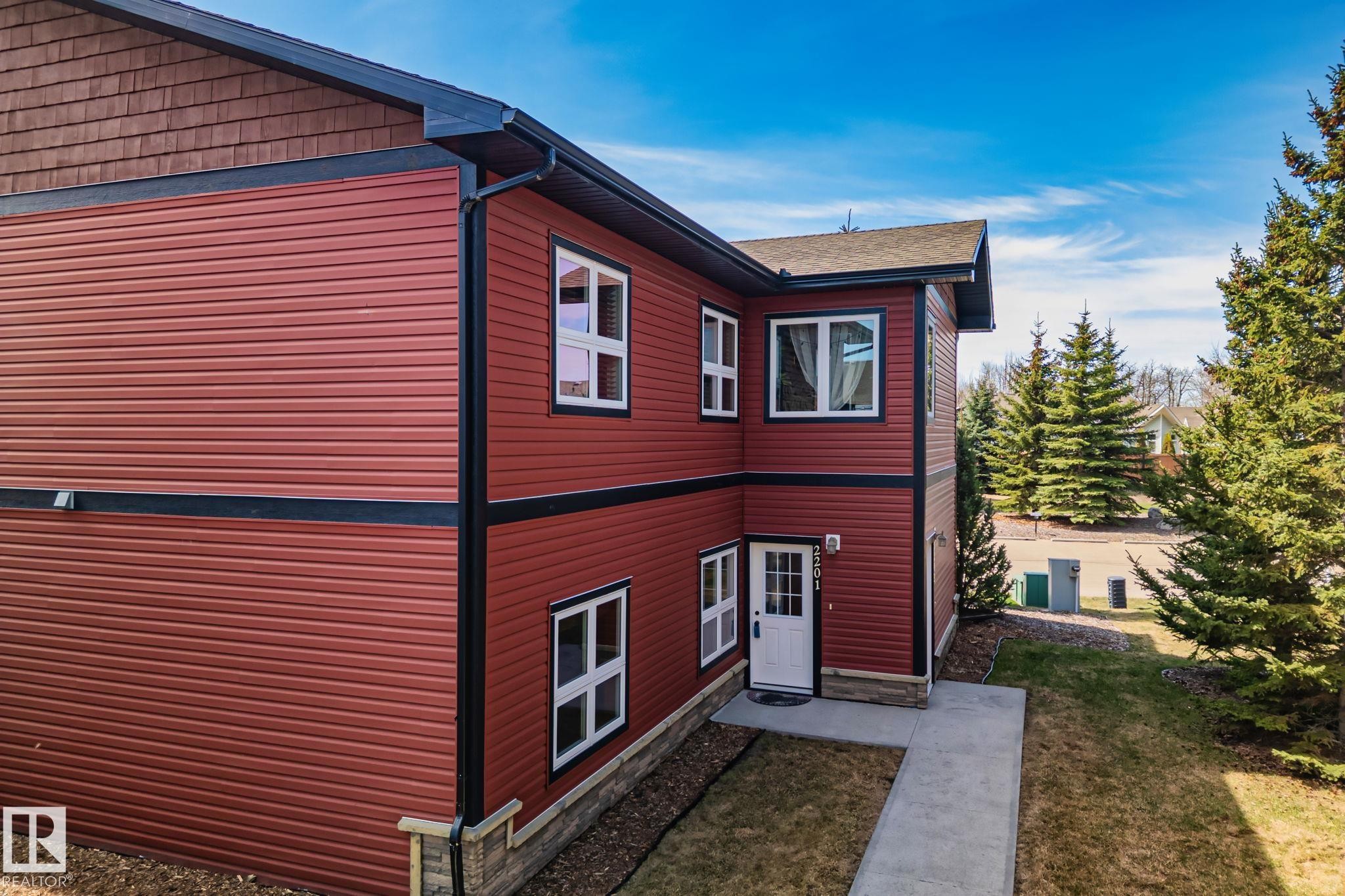 Red horizontal siding exterior with black trim and white-framed windows - 2201 Graybriar Green, Stony Plain, AB - Outdoor With Exterior