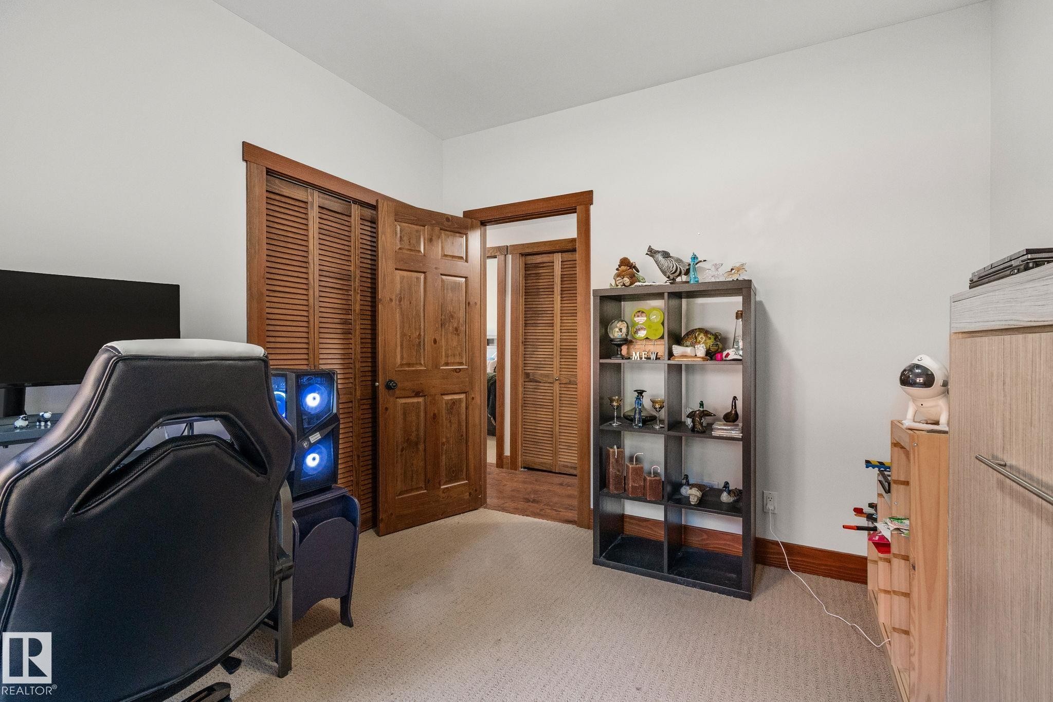 Room featuring neutral wall paint, light-toned carpeting, and warm wood-finish doors with matching trim - 2201 Graybriar Green, Stony Plain, AB - Indoor