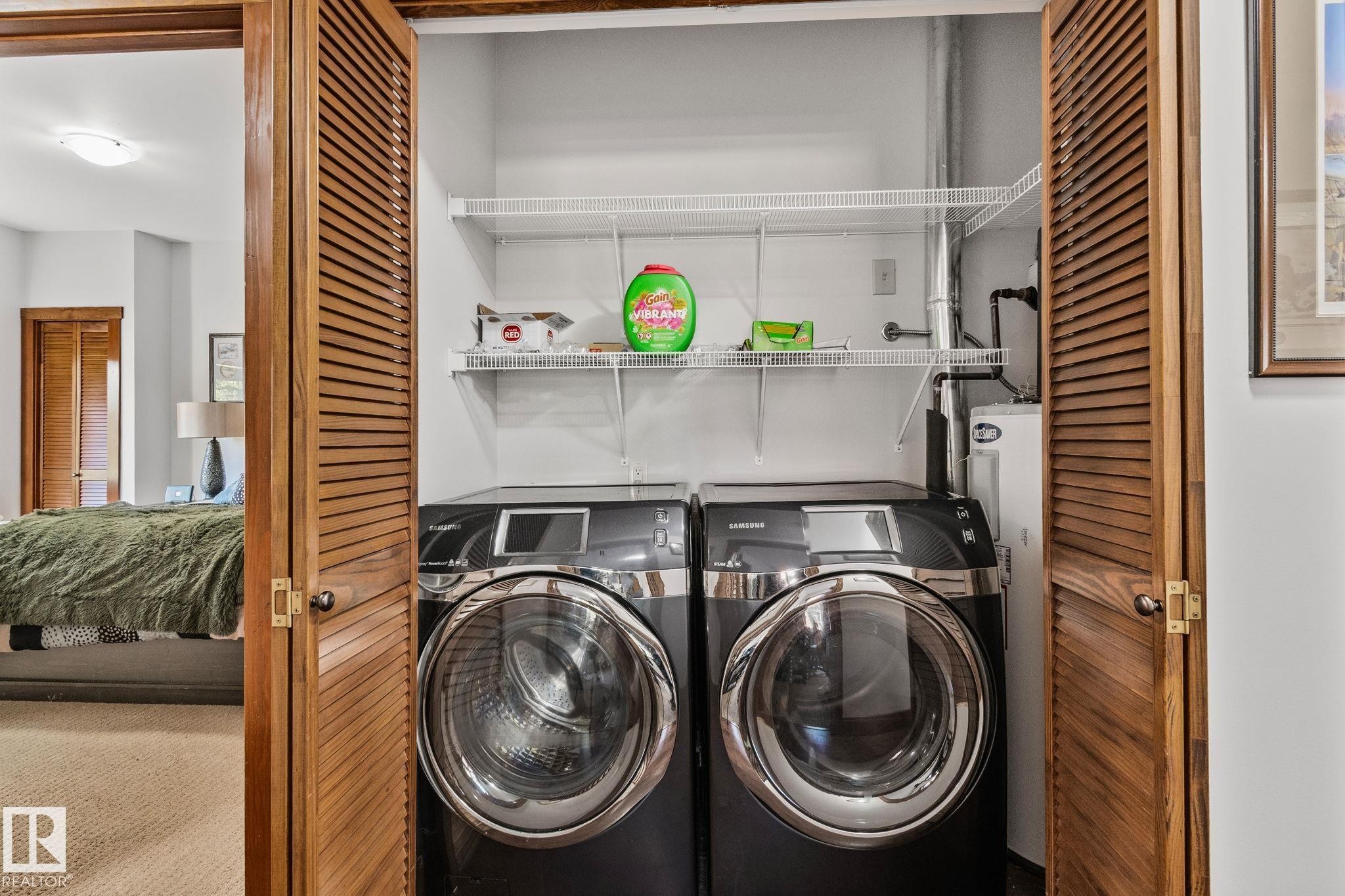 Laundry closet with louvered bi-fold doors, wire shelving, and plumbed connections - 2201 Graybriar Green, Stony Plain, AB - Indoor Photo Showing Laundry Room