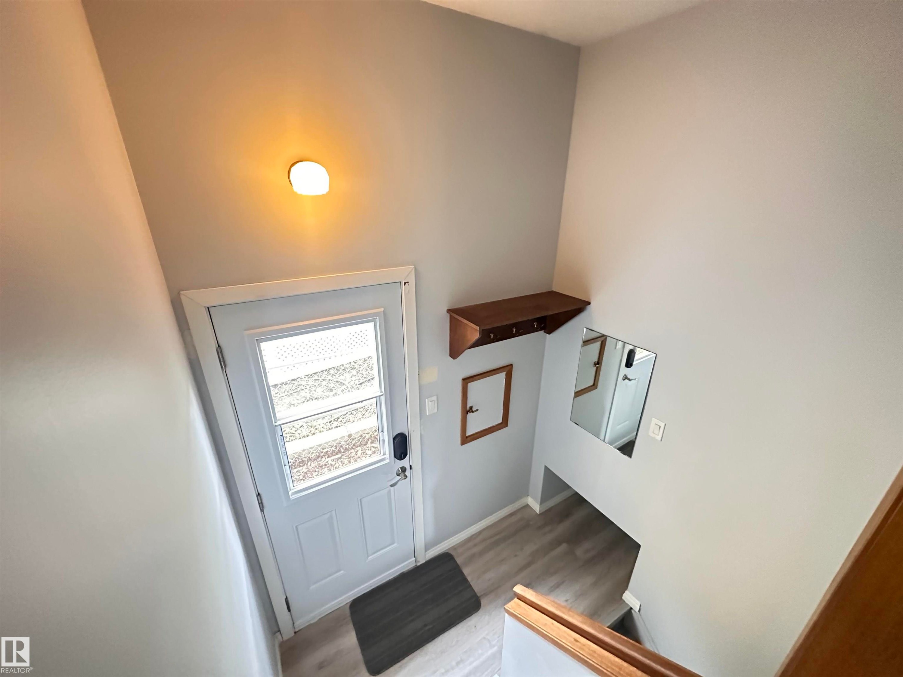 Entry foyer featuring light gray walls and wood-finish flooring - 11131 52 Street, Edmonton, AB - Indoor Photo Showing Other Room