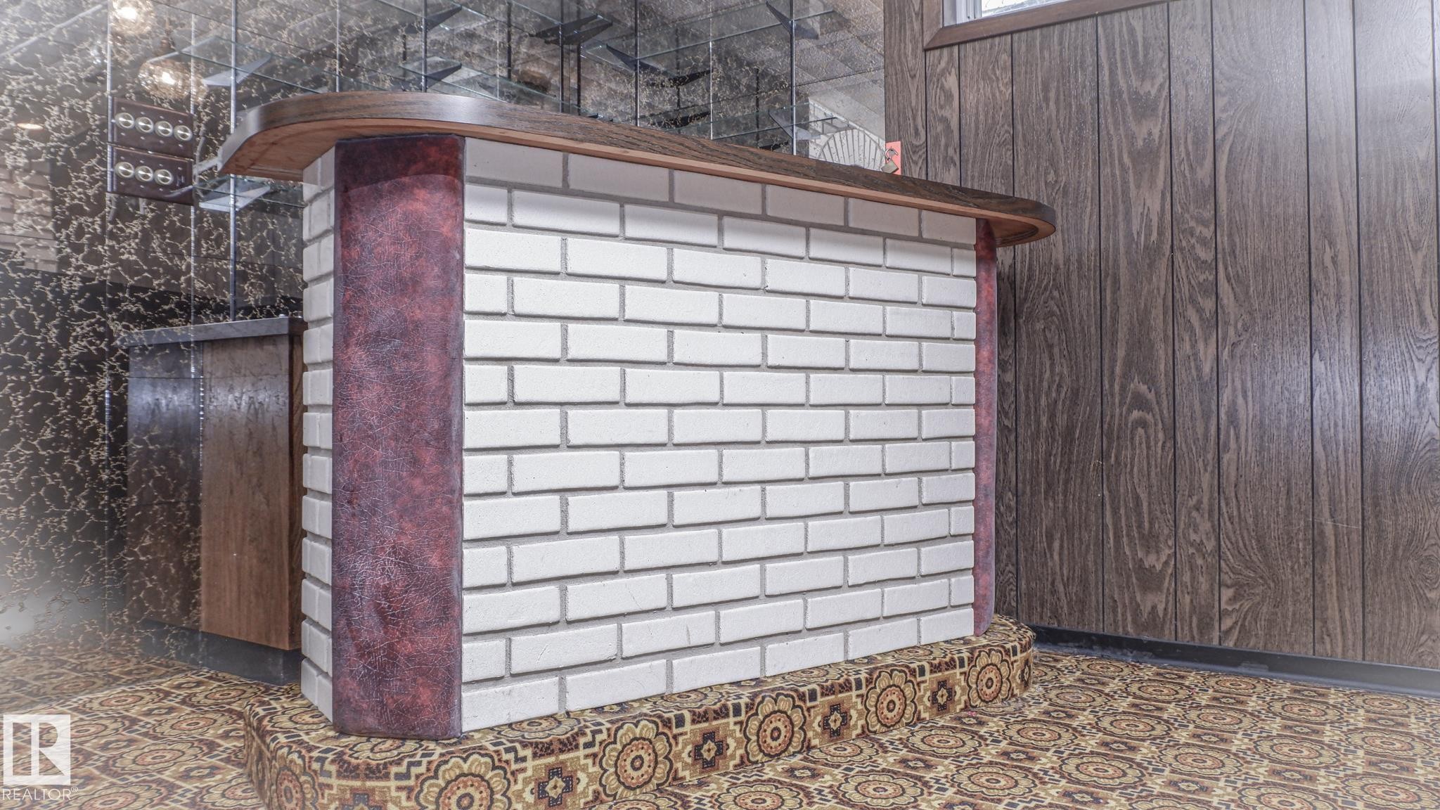Built-in bar featuring white brick detailing, a wood-finish countertop, and decorative patterned flooring - 11131 52 Street, Edmonton, AB - Outdoor