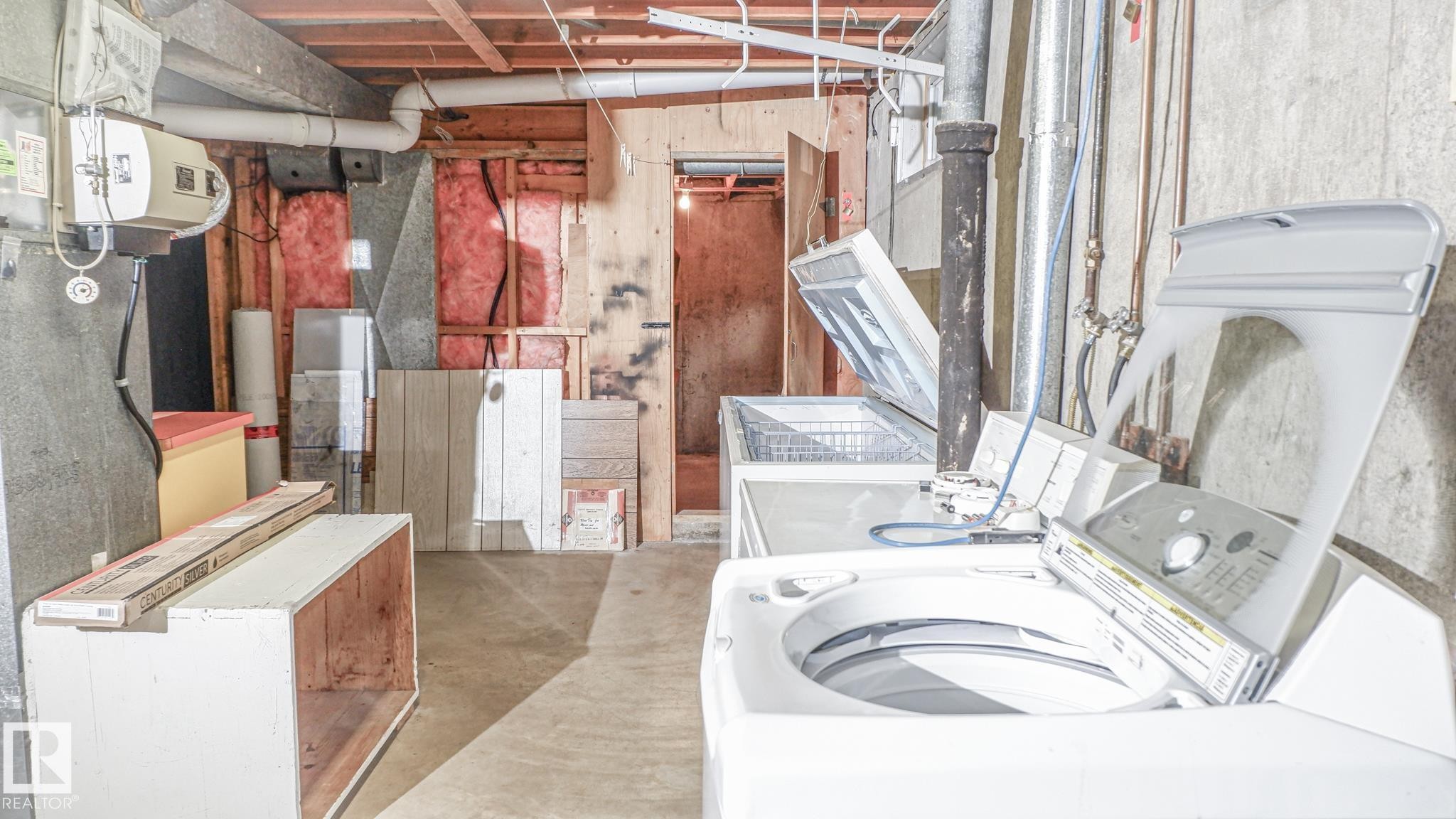Unfinished basement area featuring exposed ceiling joists, concrete flooring, and visible plumbing and ductwork - 11131 52 Street, Edmonton, AB - Indoor Photo Showing Laundry Room