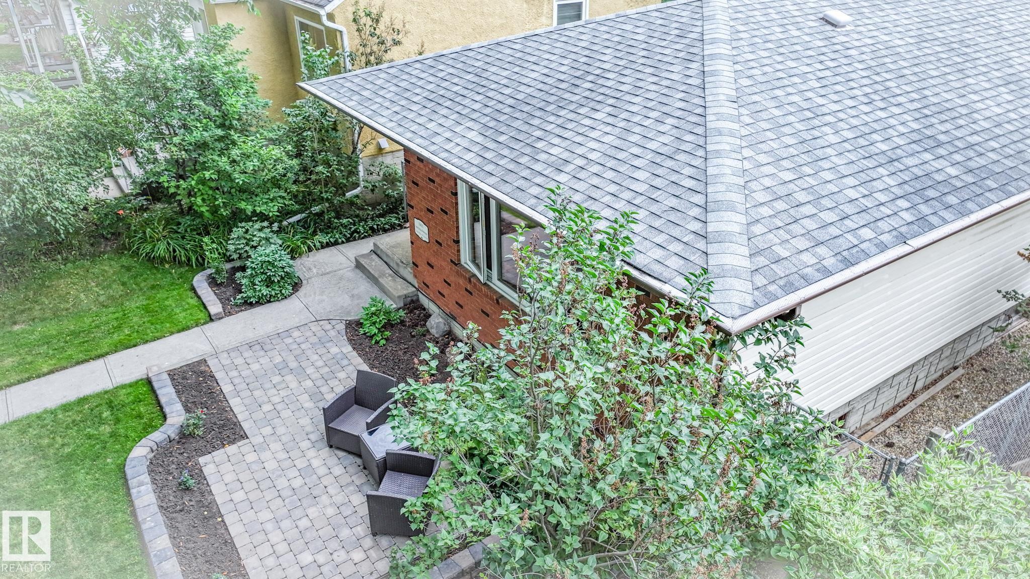 Exterior featuring a brick facade, gray shingle roof, and white siding - 11131 52 Street, Edmonton, AB - Outdoor