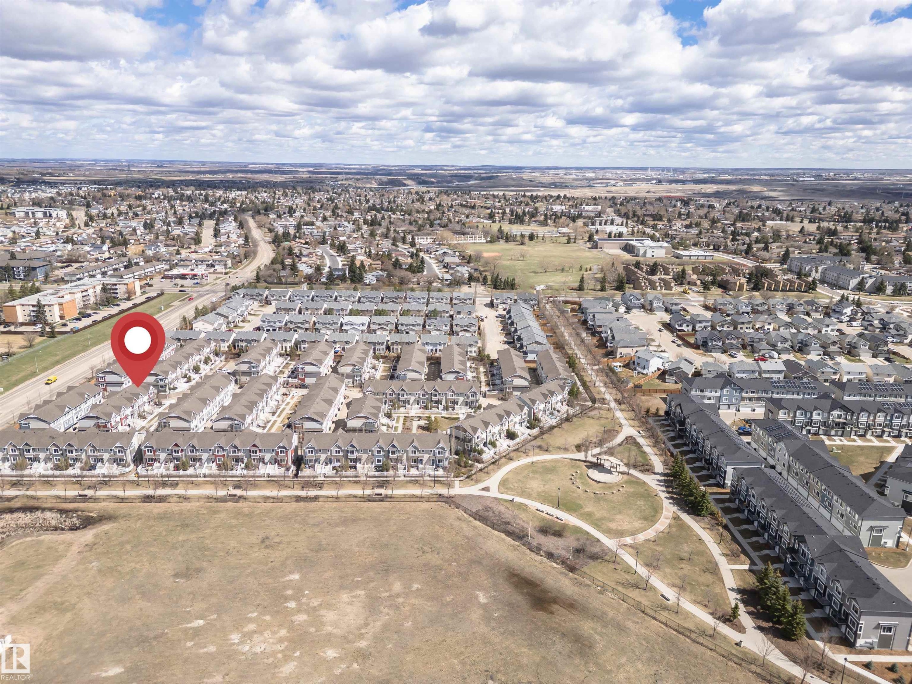 Aerial perspective showcasing a residential community with numerous townhome-style properties - #110 3625 144 Av Nw, Edmonton, AB - Outdoor With View