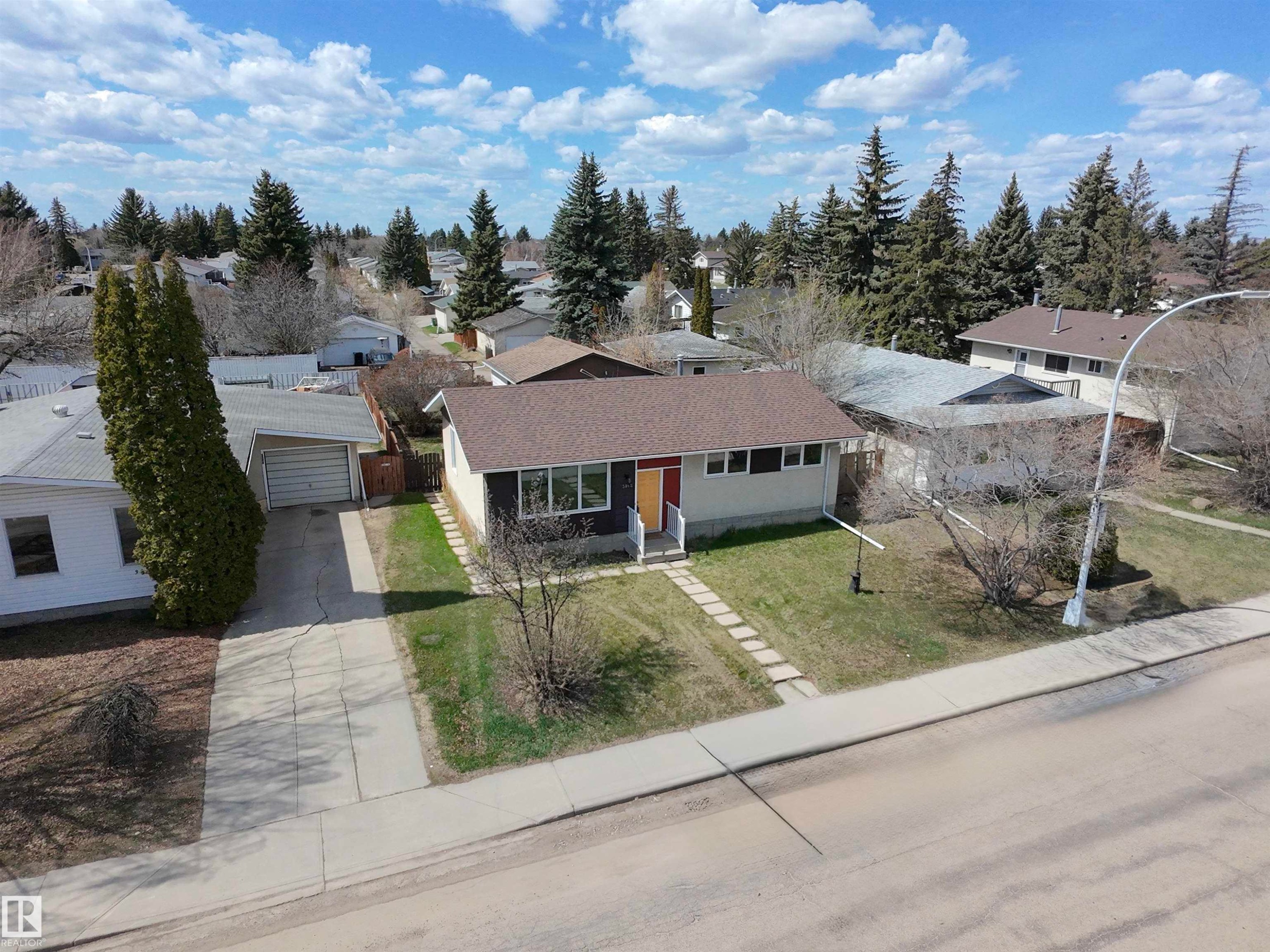 Ranch-style residence featuring a brown shingle roof, light-toned siding, and a contrasting dark-toned facade accent - 3912 108 Street, Edmonton, AB - Outdoor