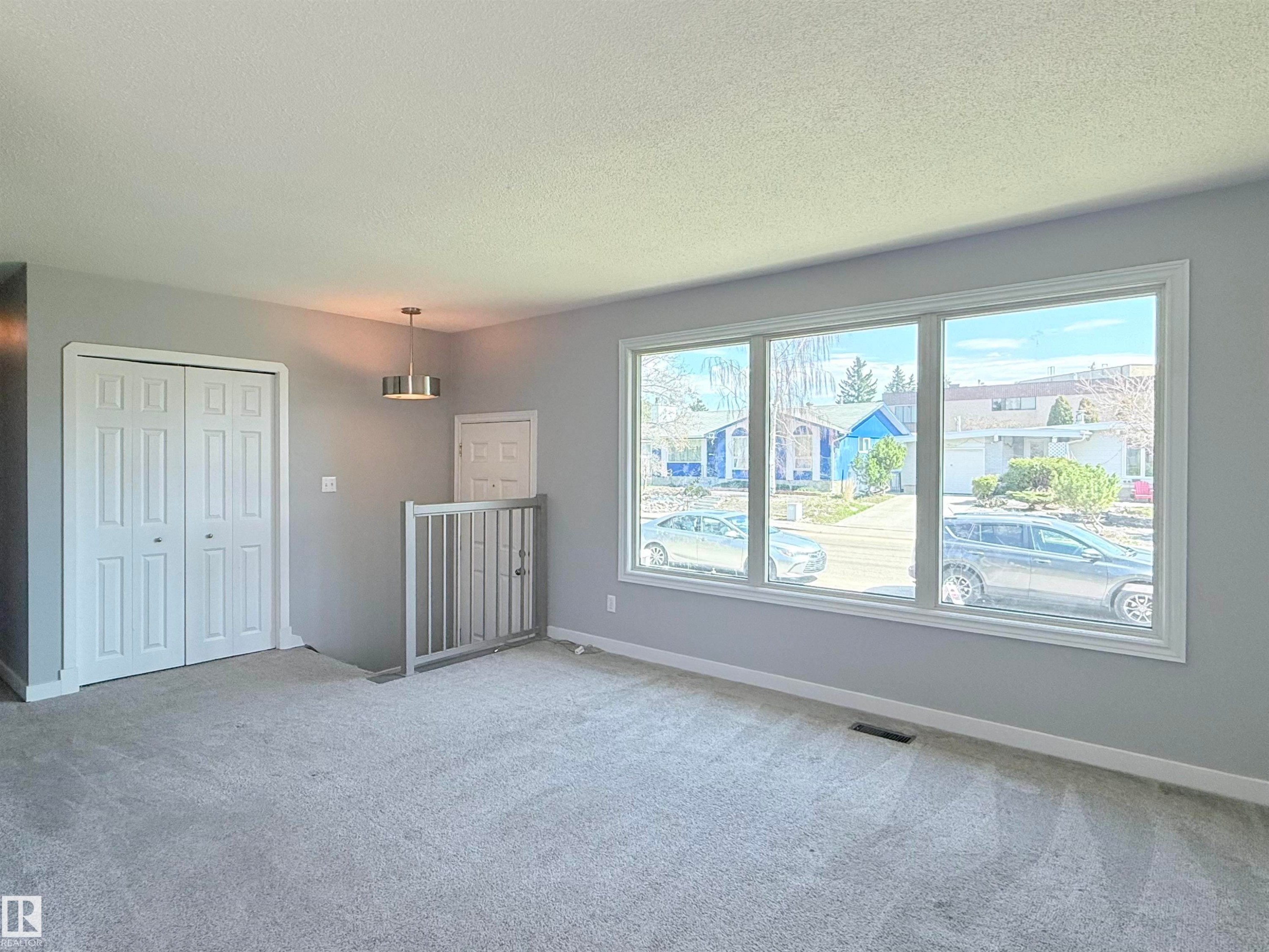 Light gray wall paint with white trim, new carpet flooring, and a three-panel window - 3912 108 Street, Edmonton, AB - Indoor