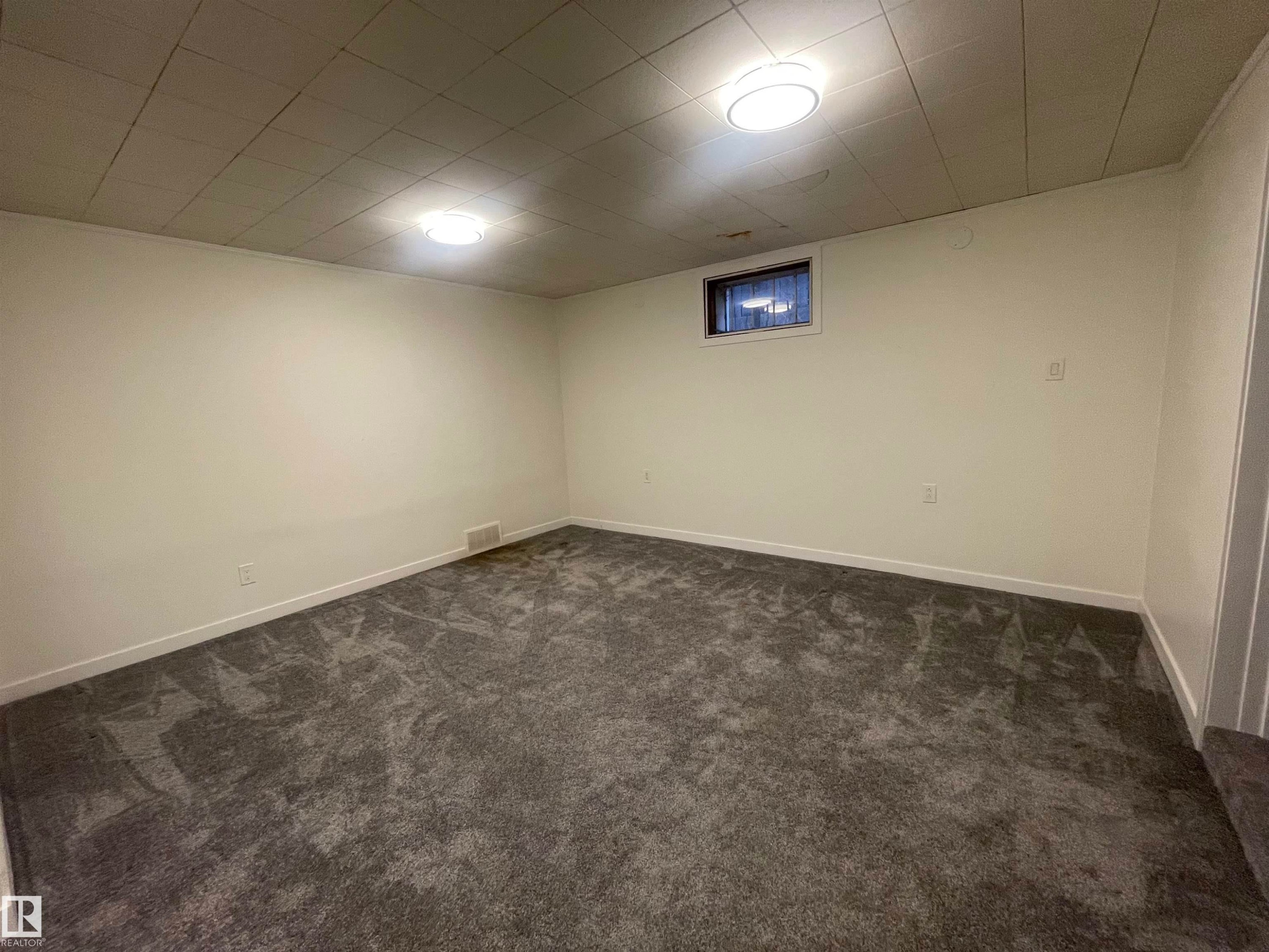 Spacious room featuring new gray carpet, white painted walls, and a drop ceiling with recessed lighting - 13804 132 Avenue, Edmonton, AB - Indoor Photo Showing Other Room