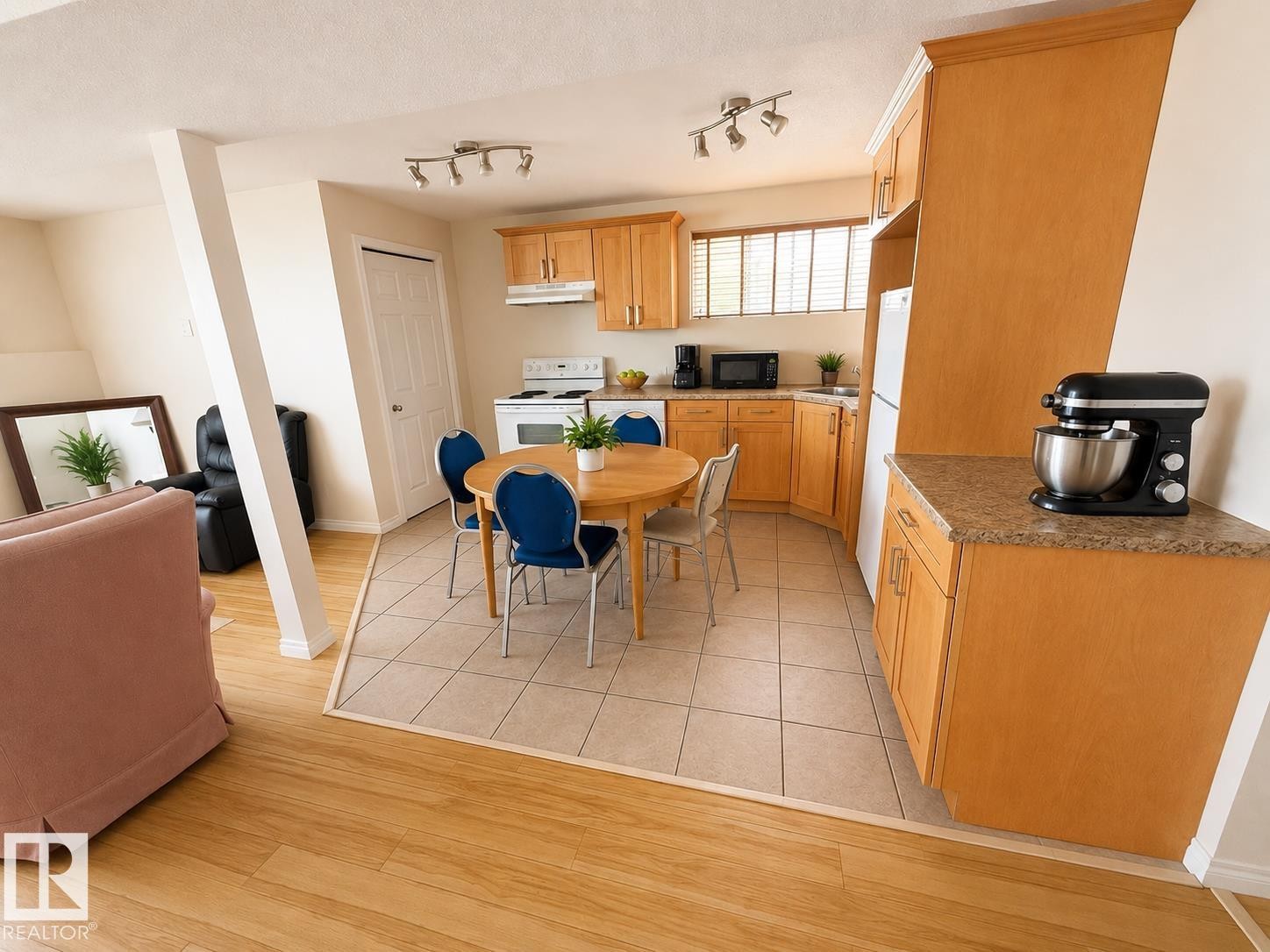 Bright kitchen featuring wood-finish cabinetry, a white electric range, and a dual-basin sink - 5712 101 Avenue, Edmonton, AB - Indoor