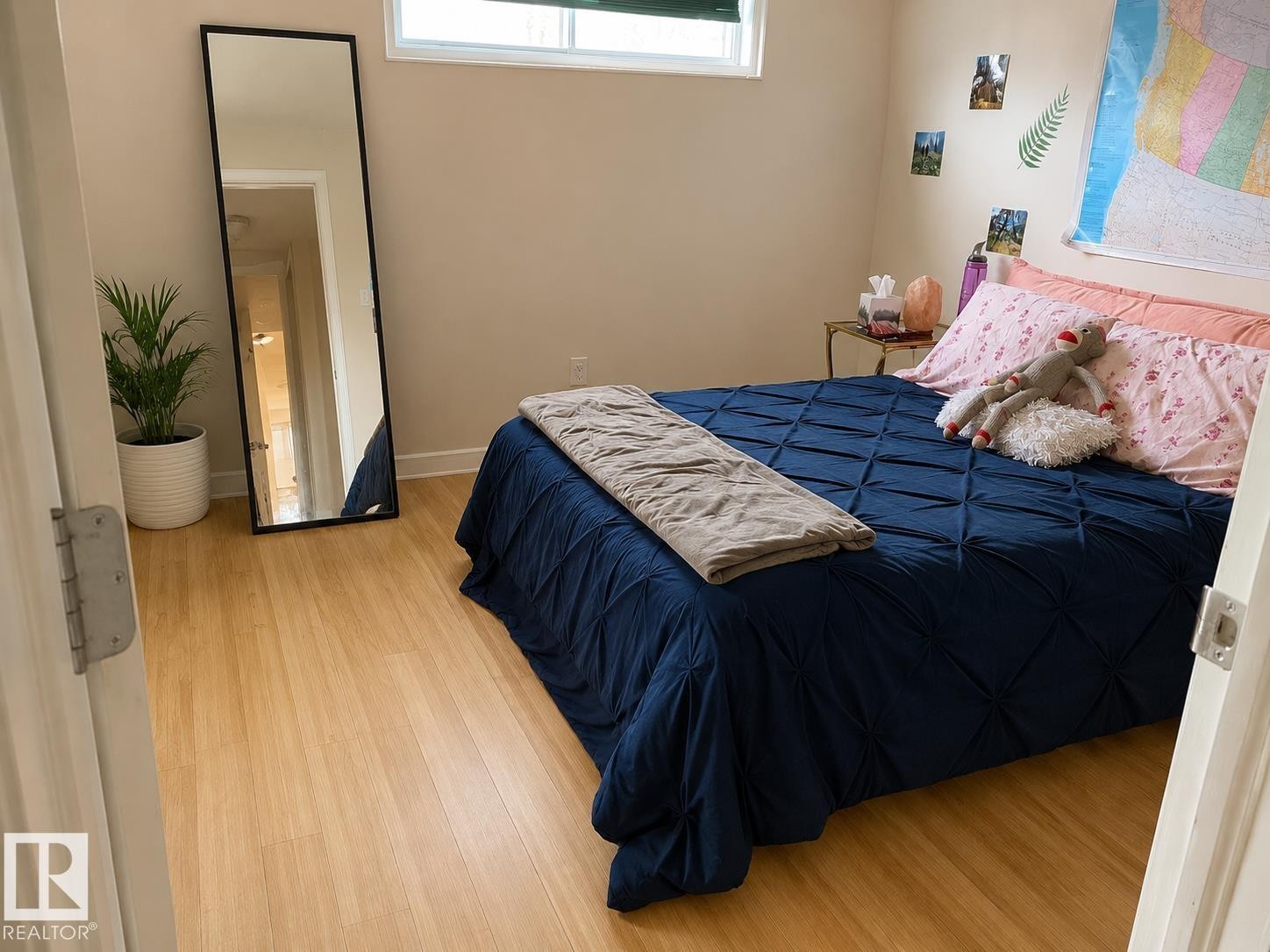 Light-toned wood-finish flooring complements neutral wall tones and white baseboards - 5712 101 Avenue, Edmonton, AB - Indoor Photo Showing Bedroom
