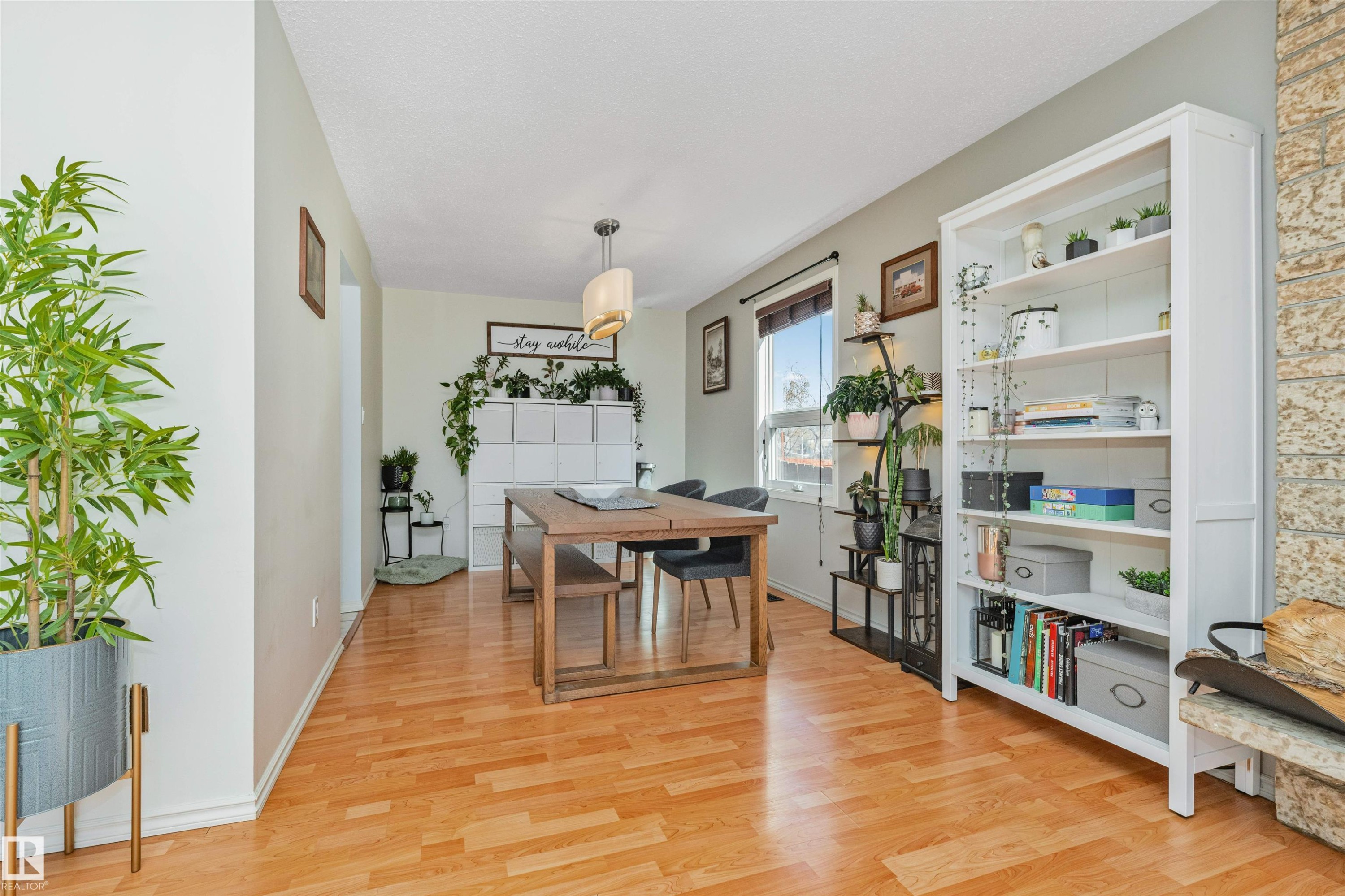 Dining area with wood-finish flooring, a contemporary ceiling light fixture, and a window with blinds - 49 Ash Crescent, St. Albert, AB - Indoor