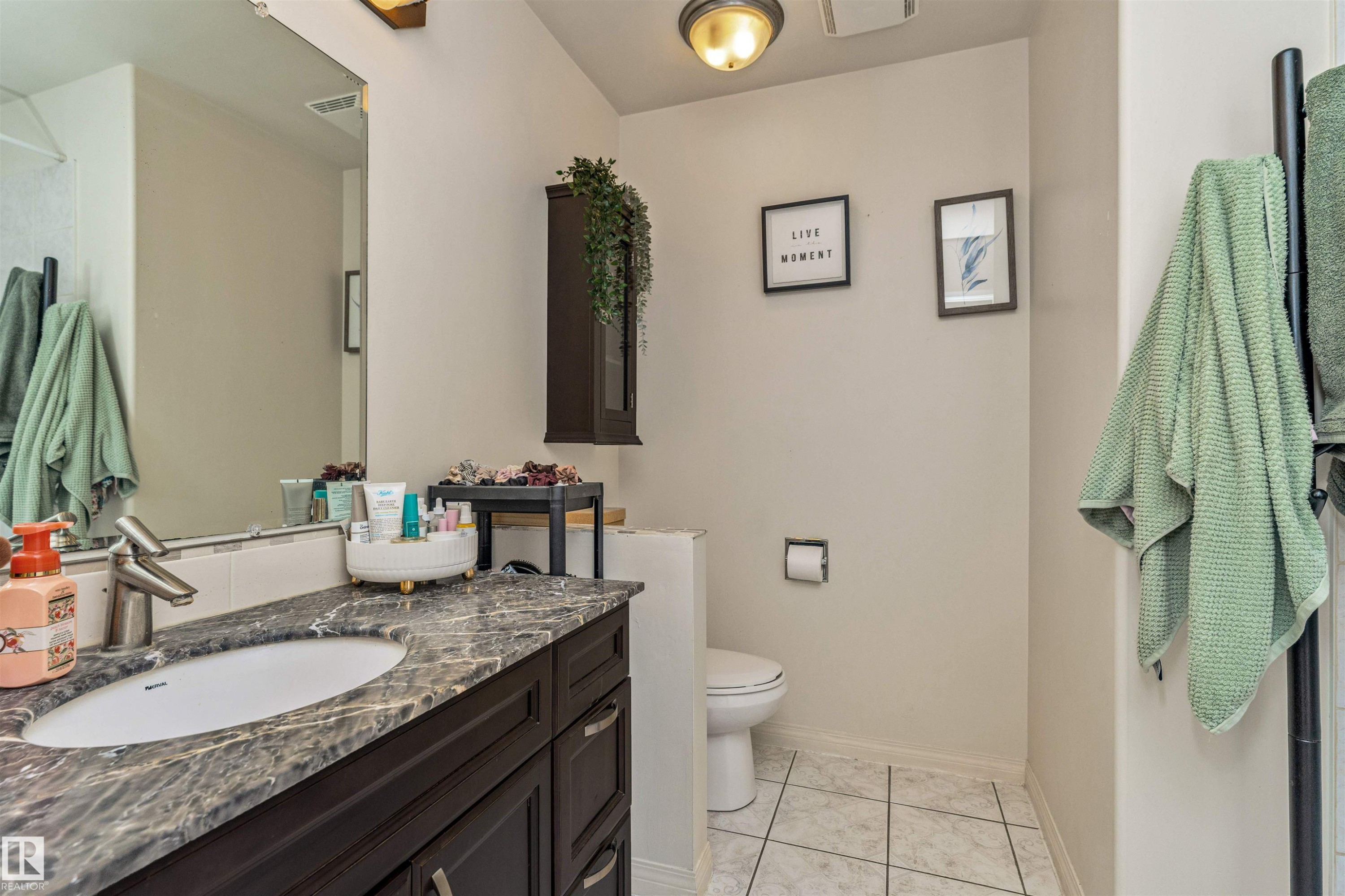 Bathroom featuring a dark wood-finish vanity with an undermount sink, a stone-finish countertop, and a large wall-mounted mirror - 49 Ash Crescent, St. Albert, AB - Indoor Photo Showing Bathroom