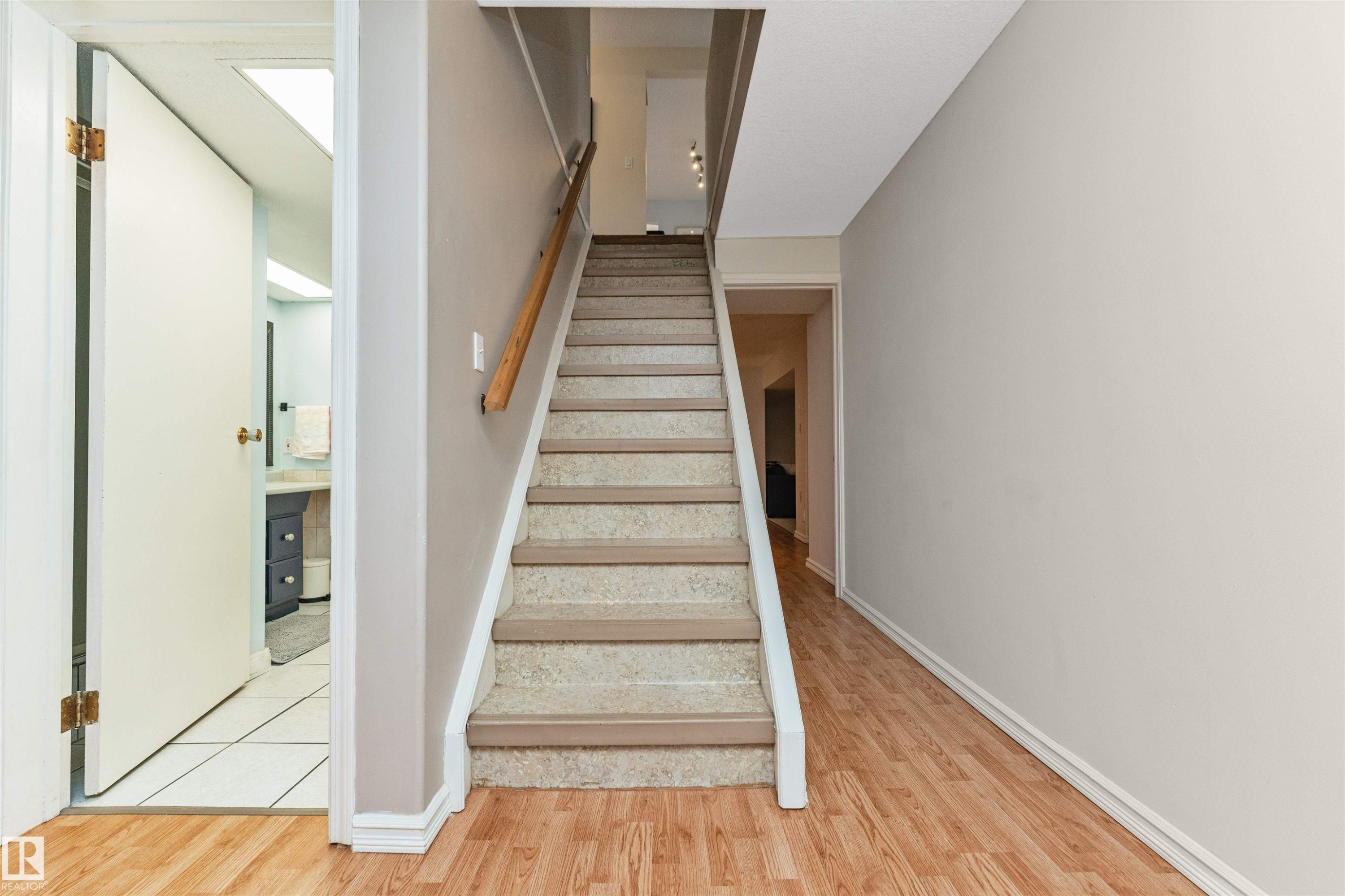 Staircase with carpeted treads and a wood handrail - 49 Ash Crescent, St. Albert, AB - Indoor Photo Showing Other Room