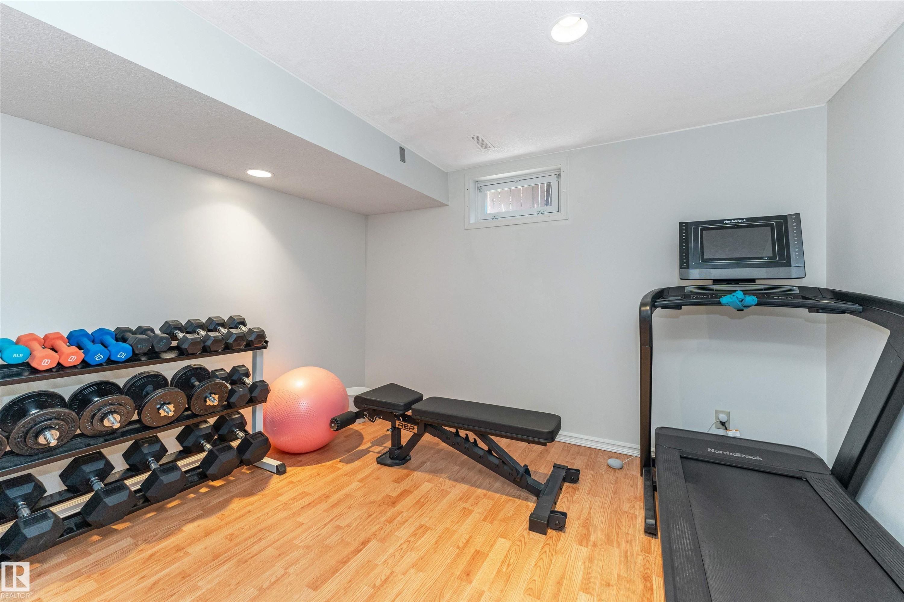 Recreational room with wood-finish flooring and recessed lighting - 49 Ash Crescent, St. Albert, AB - Indoor