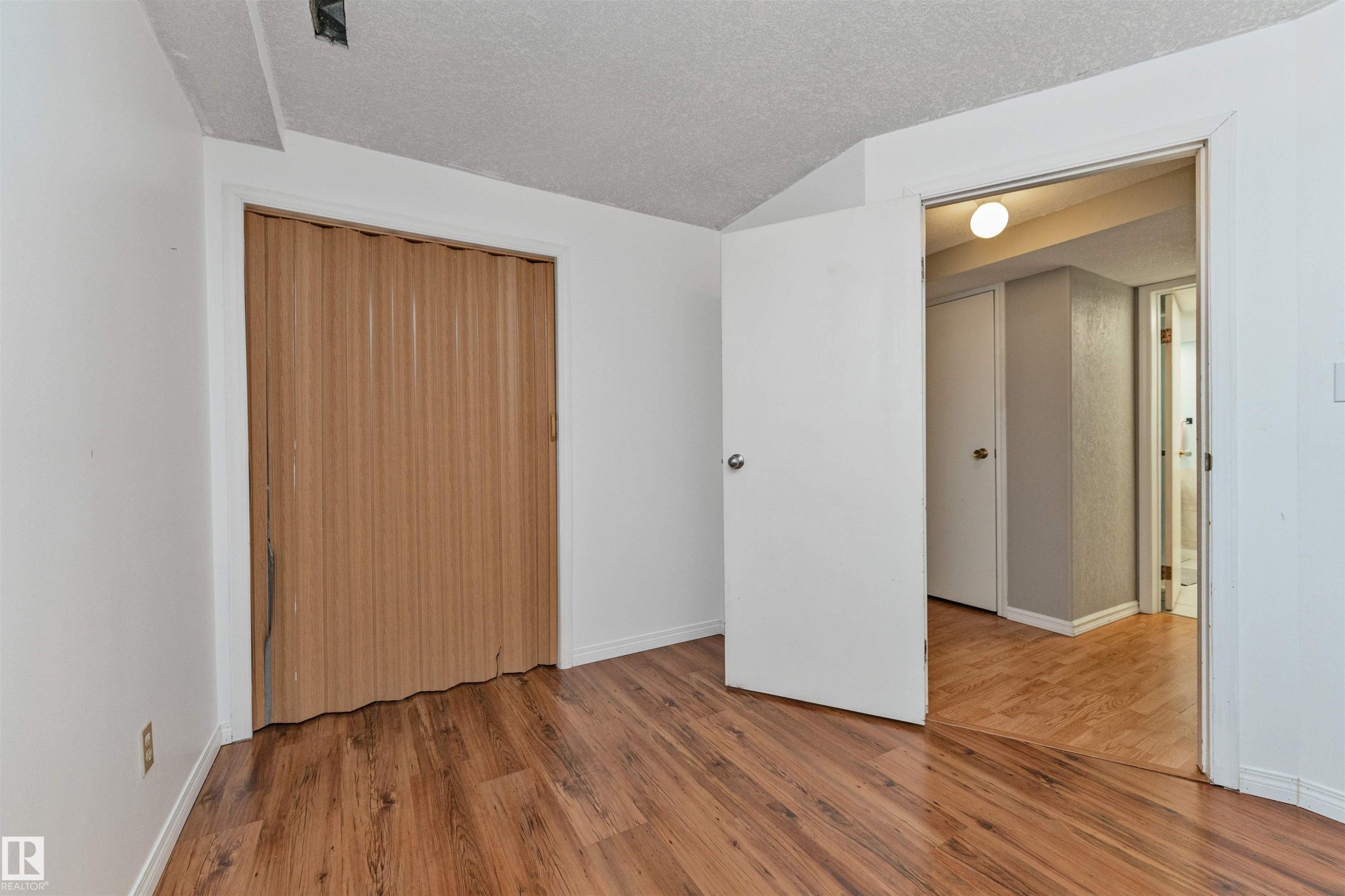 Room featuring wood-finish flooring, white walls, and a textured ceiling - 49 Ash Crescent, St. Albert, AB - Indoor Photo Showing Other Room