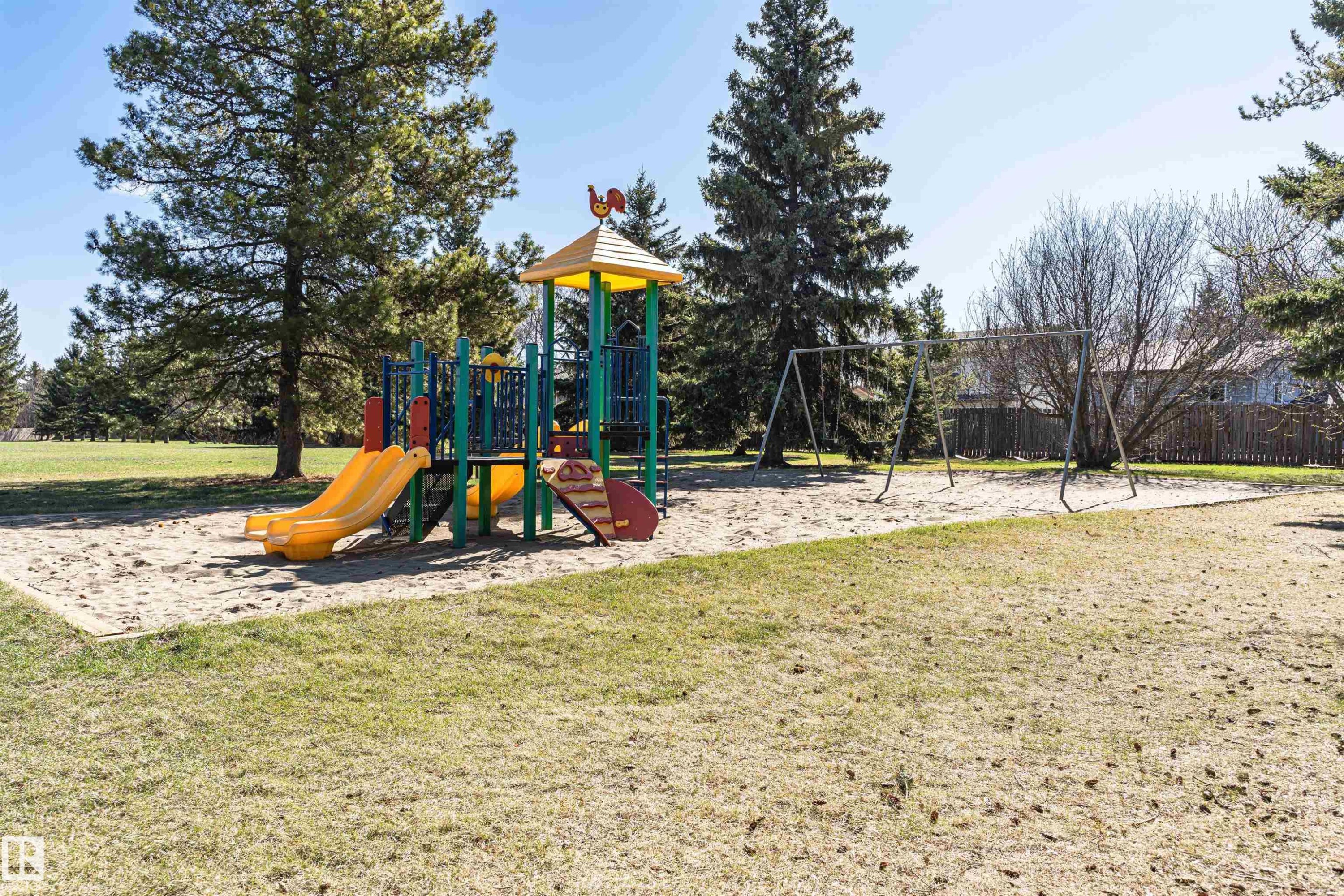 Outdoor playground featuring a colorful play structure with slides and a swing set - 49 Ash Crescent, St. Albert, AB - Outdoor