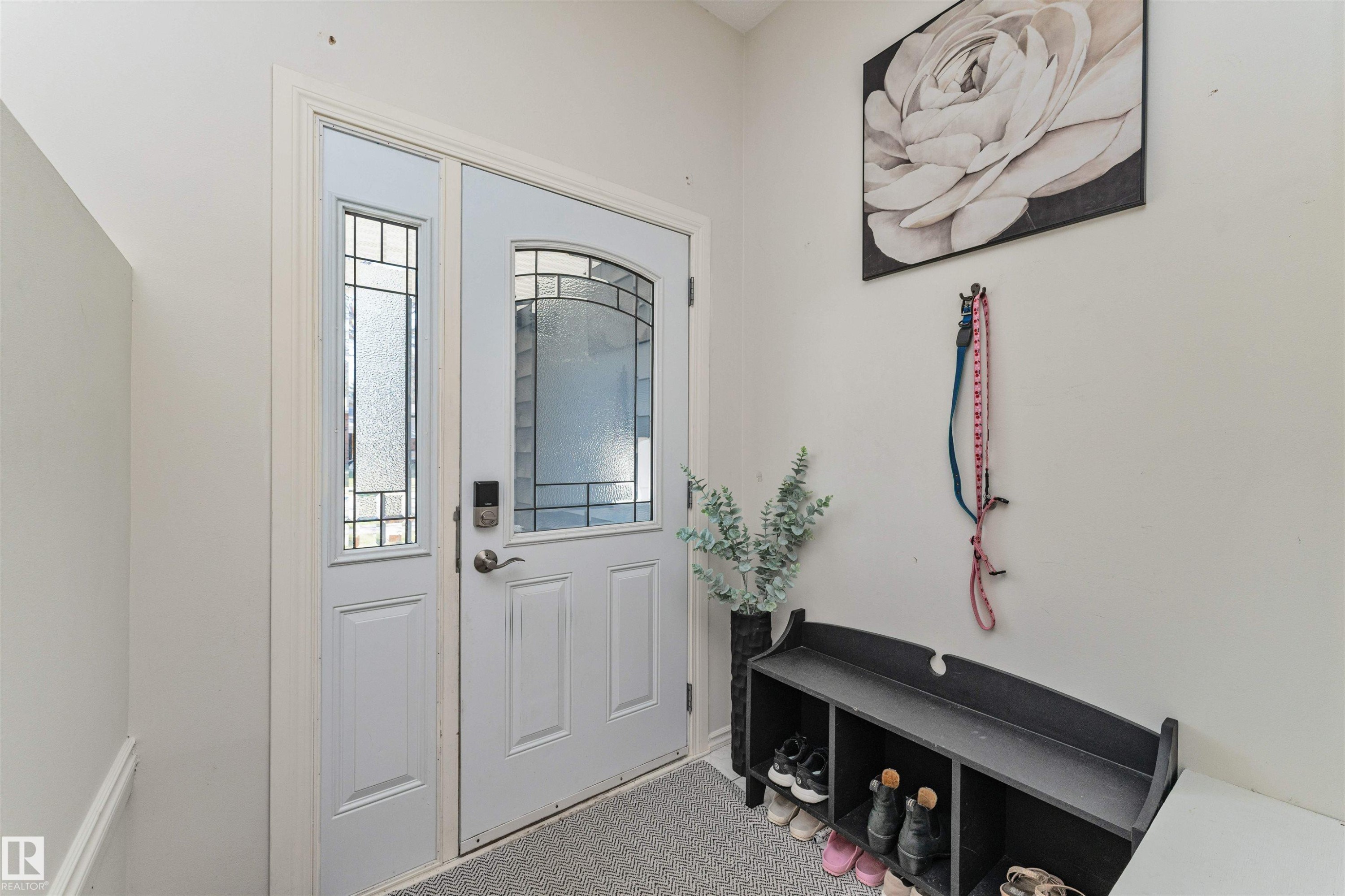 Entryway featuring a white paneled door with an arched leaded glass insert, complemented by a sidelight with clear and frosted glass - 49 Ash Crescent, St. Albert, AB - Indoor Photo Showing Other Room