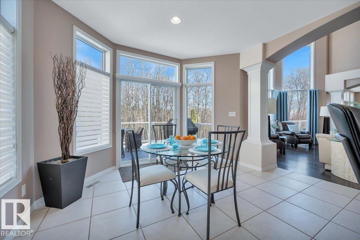 SLIDING DOOR TO THE 1ST OF TWO MAIN FLOOR PATIOS WITH VIEWS OF THE STUNNING BACK YARD - 314 Weaver Point(E), Edmonton, AB - Indoor Photo Showing Dining Room