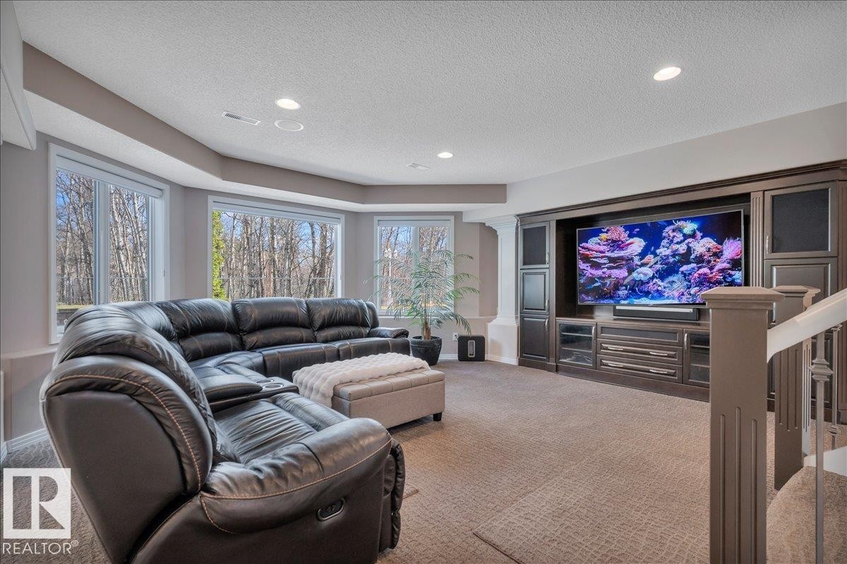 LOWER LEVEL FAMILY ROOM WITH CUSTOM ENTERTAINMENT CENTRE, BUILT BY FULL HOUSE RENOVATIONS, 78" UHD CURVED TV, SONOS SOUND BAR AND SUB WOOFER - 314 Weaver Point(E), Edmonton, AB - Indoor Photo Showing Living Room