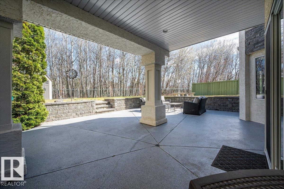 LOWER LEVEL PATIO FROM THE BASEMENT WITH CENTRE DRAIN AND STONE RETAINING WALLS - 314 Weaver Point(E), Edmonton, AB - Outdoor With Exterior