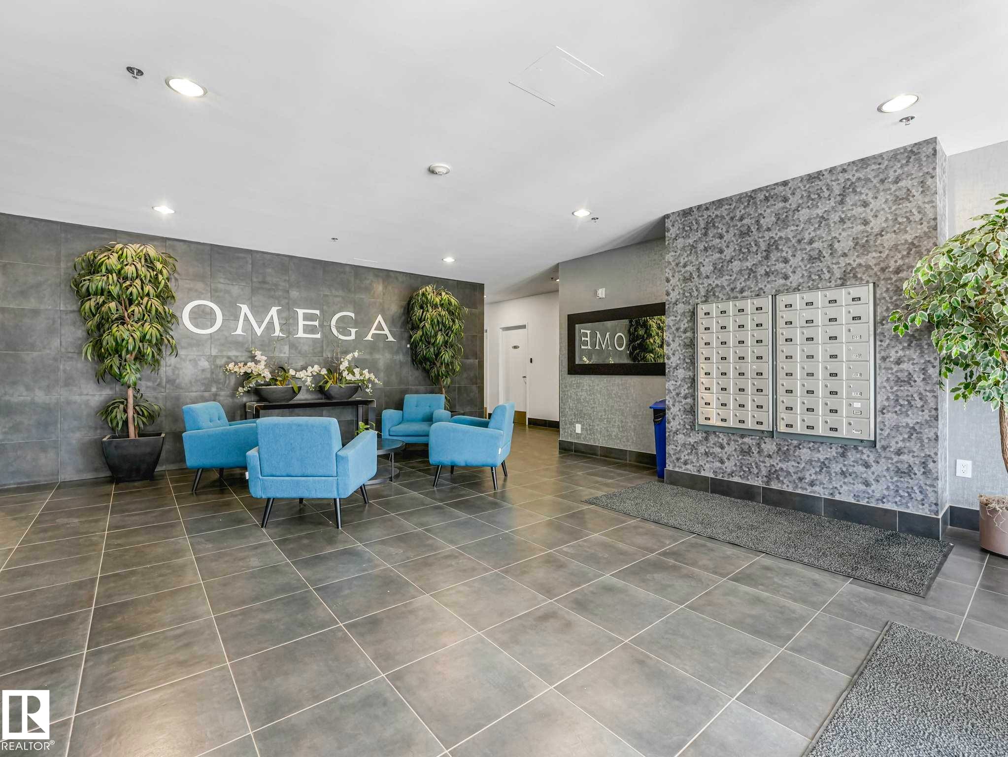 Modern building lobby featuring large format gray tile flooring and textured accent walls - 305 10504 99 Avenue, Edmonton, AB - Indoor Photo Showing Other Room