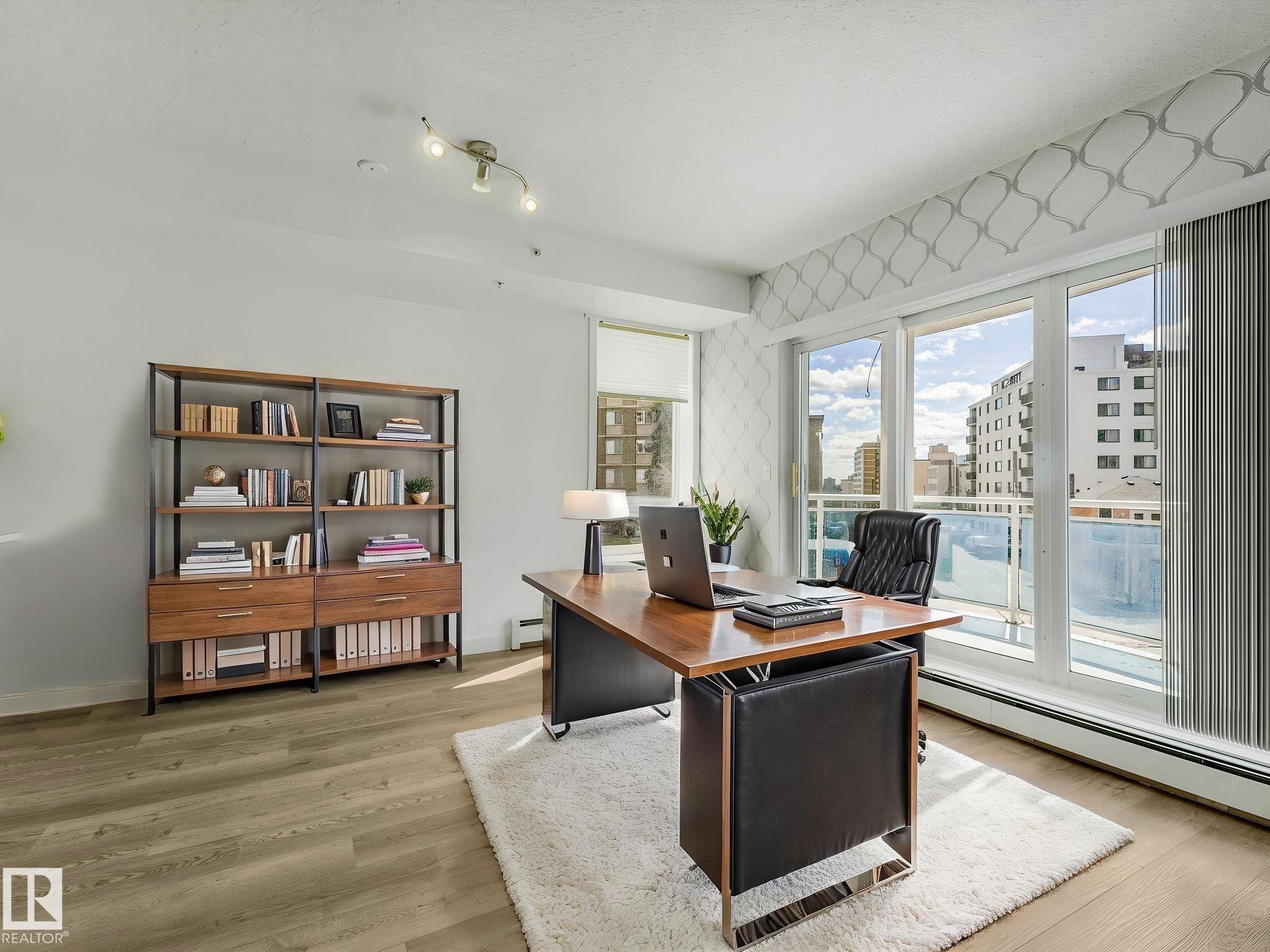 Bright room featuring wood-finish flooring and a built-in bookshelf - 305 10504 99 Avenue, Edmonton, AB - Indoor Photo Showing Office