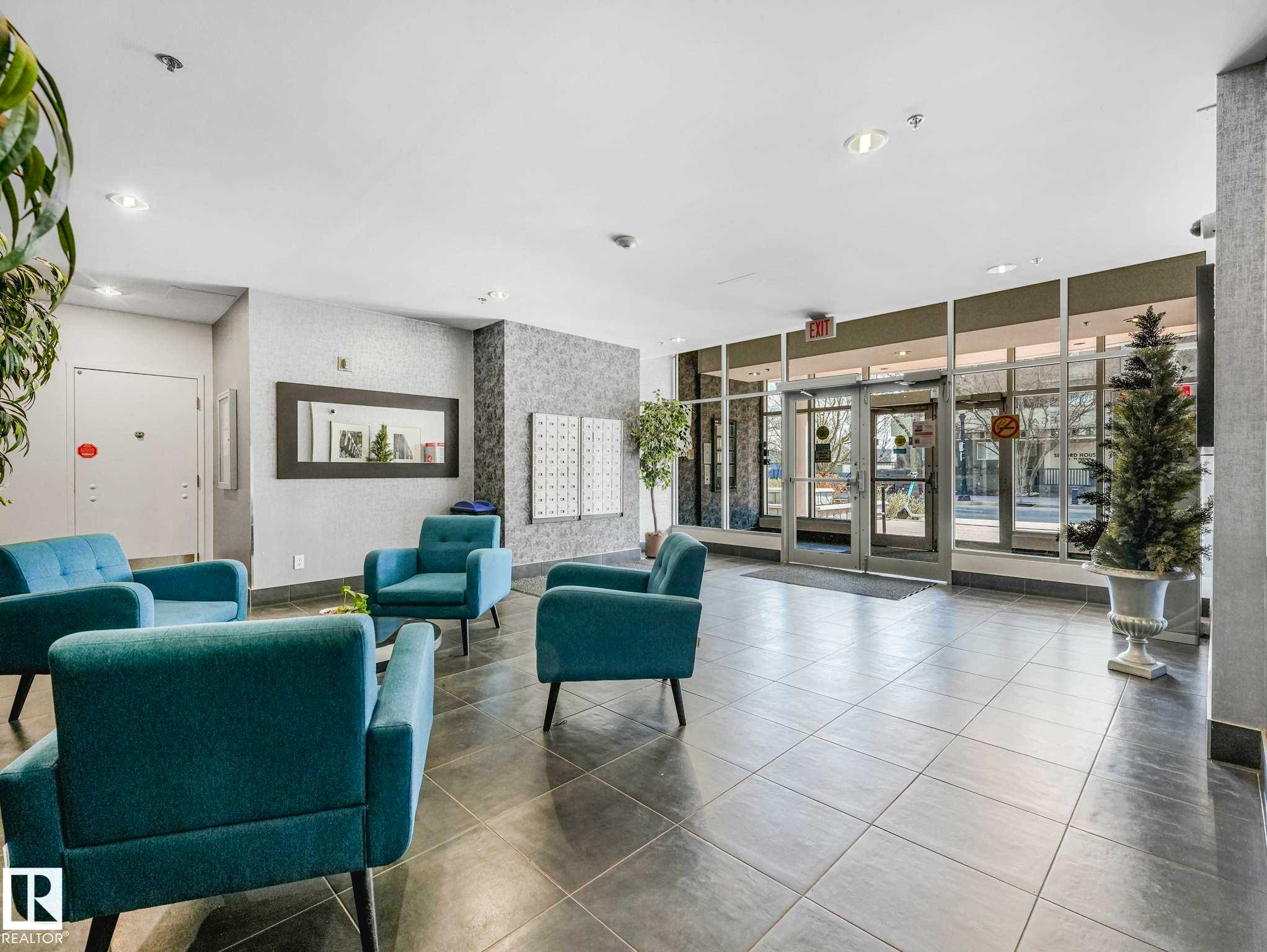 Lobby area featuring large format tile flooring, a textured accent wall, and a full-height glass entry system - 305 10504 99 Avenue, Edmonton, AB - Indoor