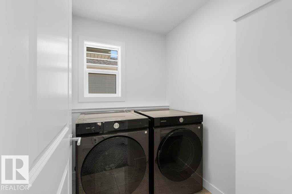 Dedicated laundry area featuring a white-framed window, light wall paint, and baseboard trim - 19110 20A Avenue, Edmonton, AB - Indoor Photo Showing Laundry Room