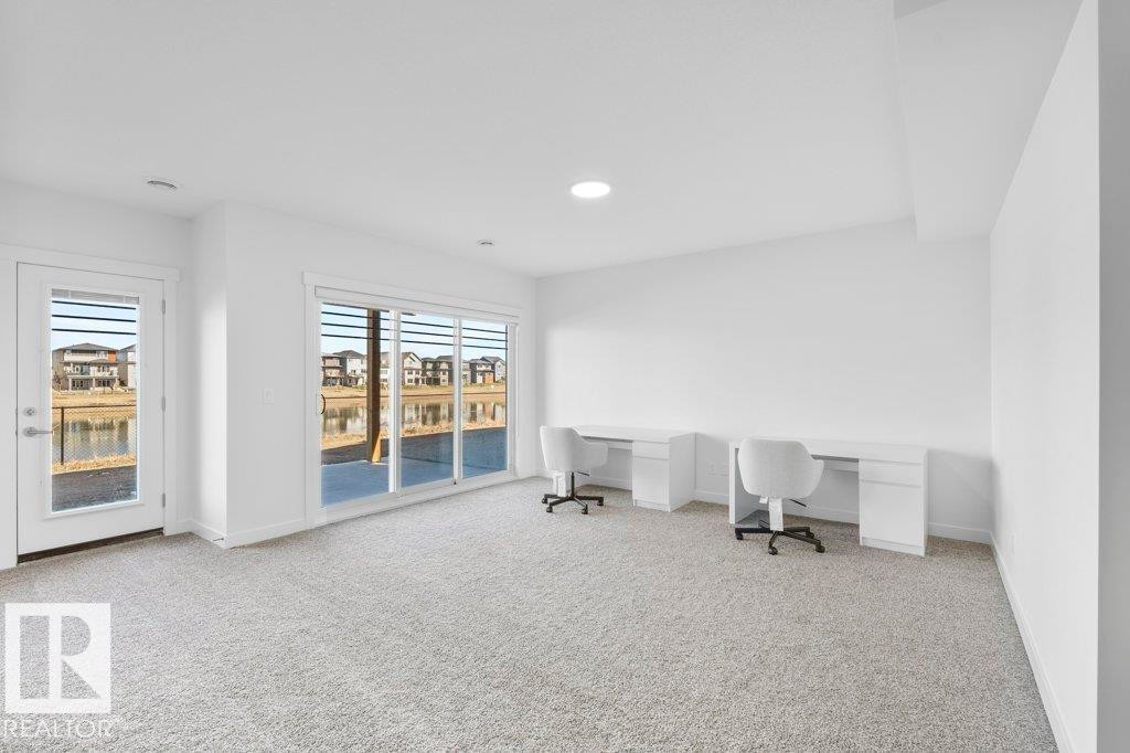 Carpeted room with a sliding glass door and an additional glass-paneled door opening to an outdoor patio - 19110 20A Avenue, Edmonton, AB - Indoor