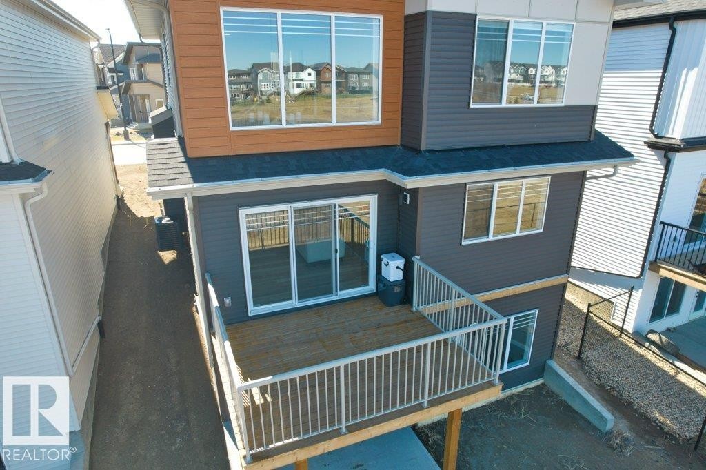 Multi-level exterior with a ground-level deck featuring white railings - 19110 20A Avenue, Edmonton, AB - Outdoor With Exterior