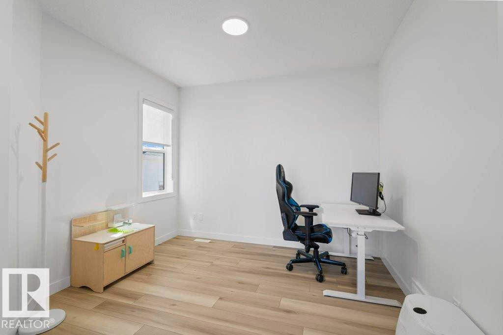 Well-lit room featuring light wood-finish flooring and crisp white walls - 19110 20A Avenue, Edmonton, AB - Indoor Photo Showing Office