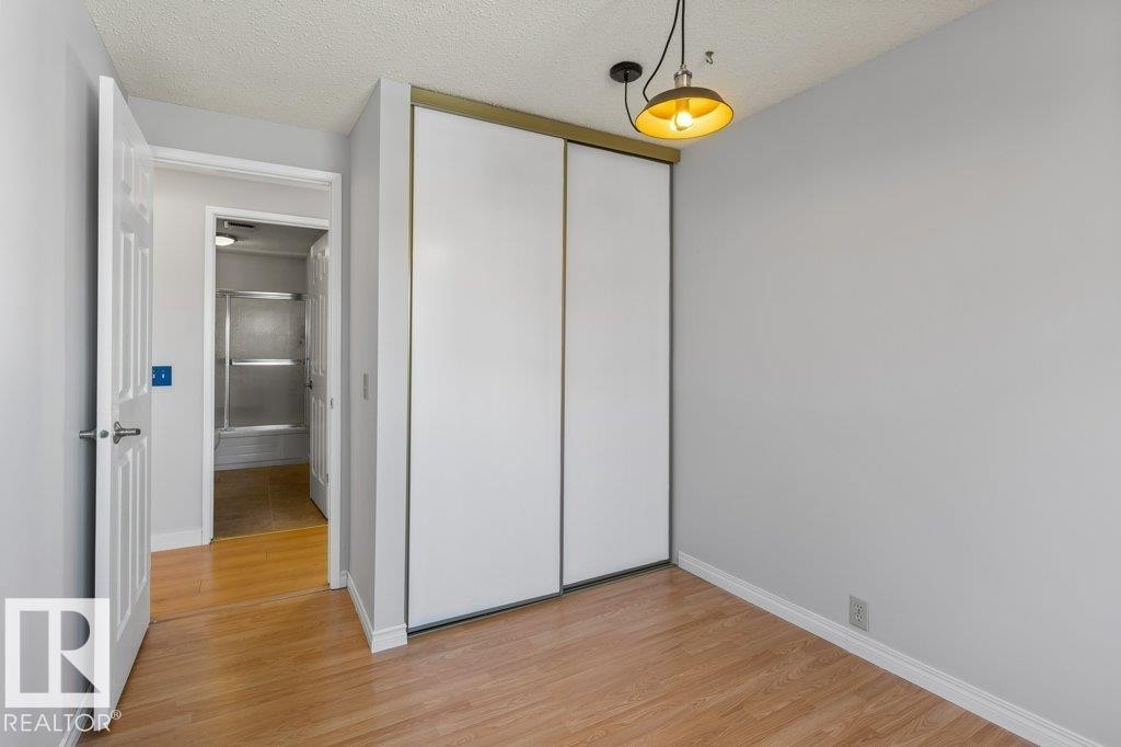 Interior room featuring wood-finish flooring, light grey painted walls, and white baseboards - 3736 12 Avenue, Edmonton, AB - Indoor Photo Showing Other Room