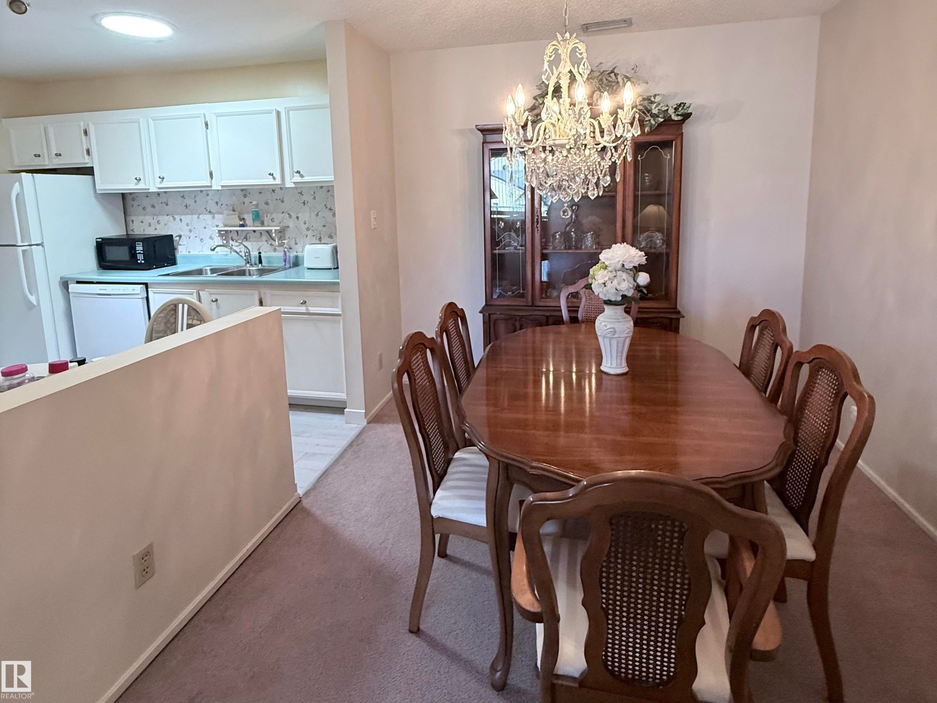 Dining area featuring a crystal chandelier, wood-finish flooring, and neutral wall tones - 2071 Saddleback Road, Edmonton, AB - Indoor Photo Showing Dining Room