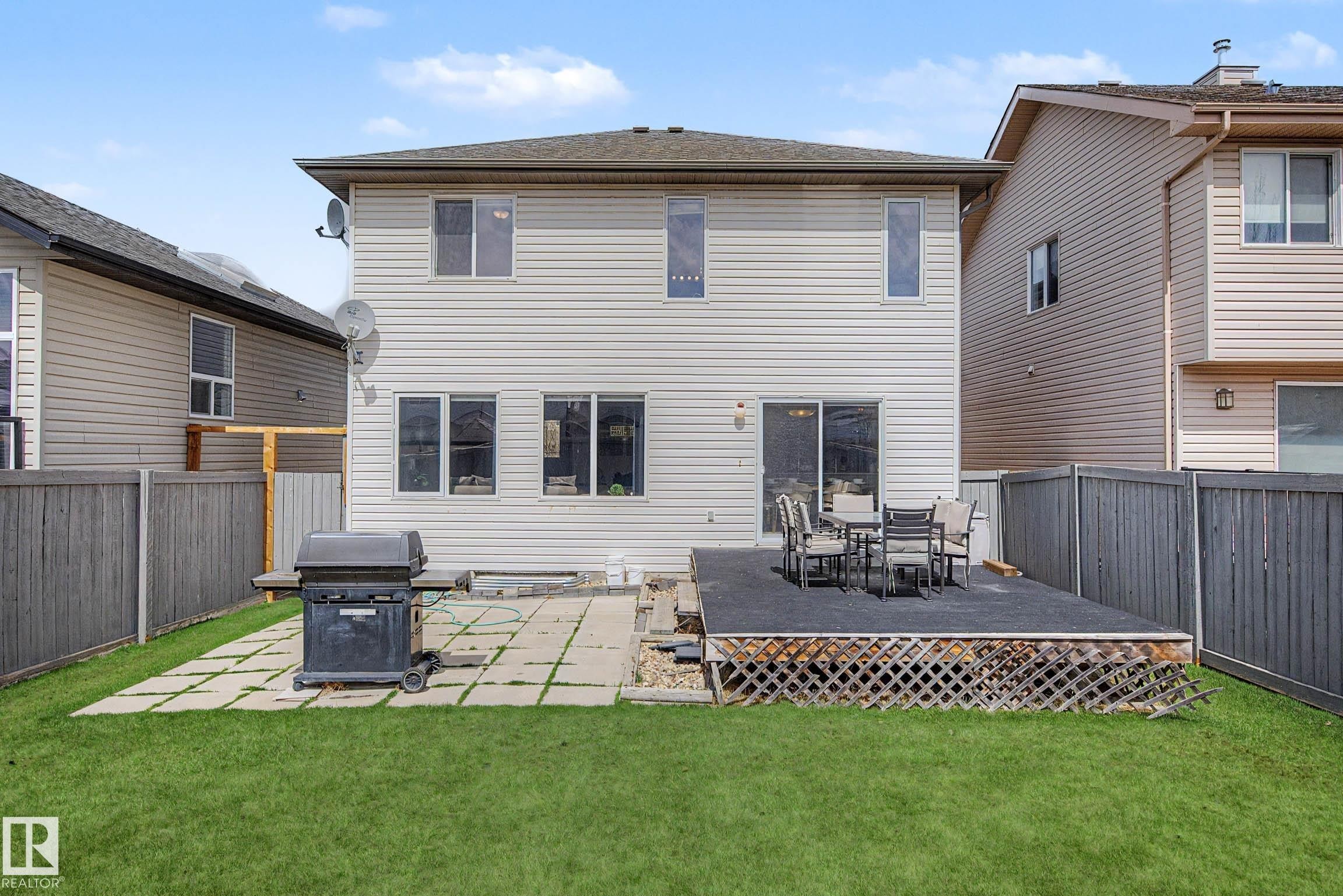 Spacious backyard featuring a multi-level deck, a concrete patio, and a manicured lawn - 7723 7A Avenue, Edmonton, AB - Outdoor With Deck Patio Veranda With Exterior
