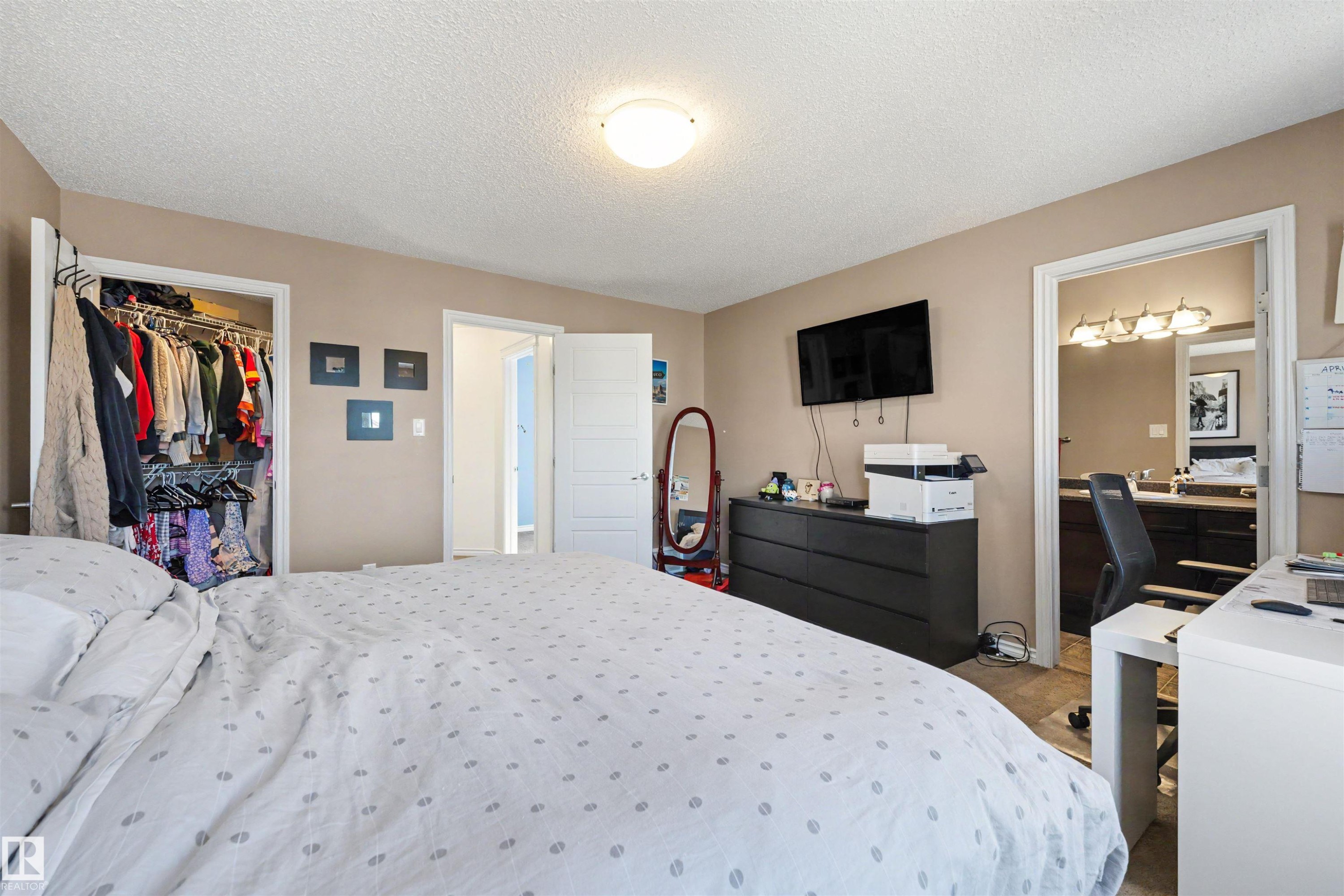 Bedroom featuring neutral wall paint, overhead flush-mount lighting, and a built-in closet with shelving and hanging rods - 6115 18 Avenue, Edmonton, AB - Indoor Photo Showing Bedroom