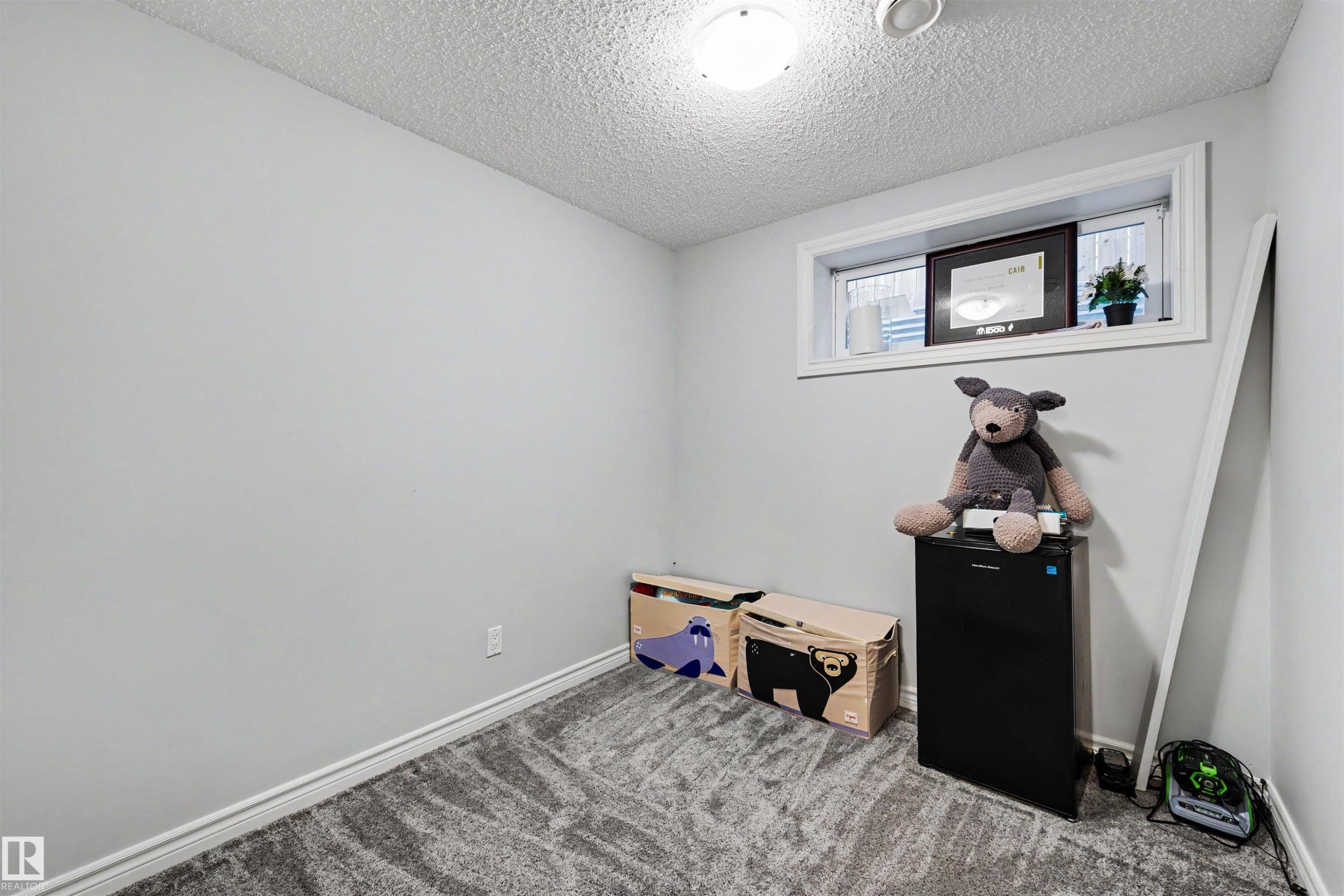 Light gray walls with a patterned carpet flooring - 6115 18 Avenue, Edmonton, AB - Indoor Photo Showing Other Room