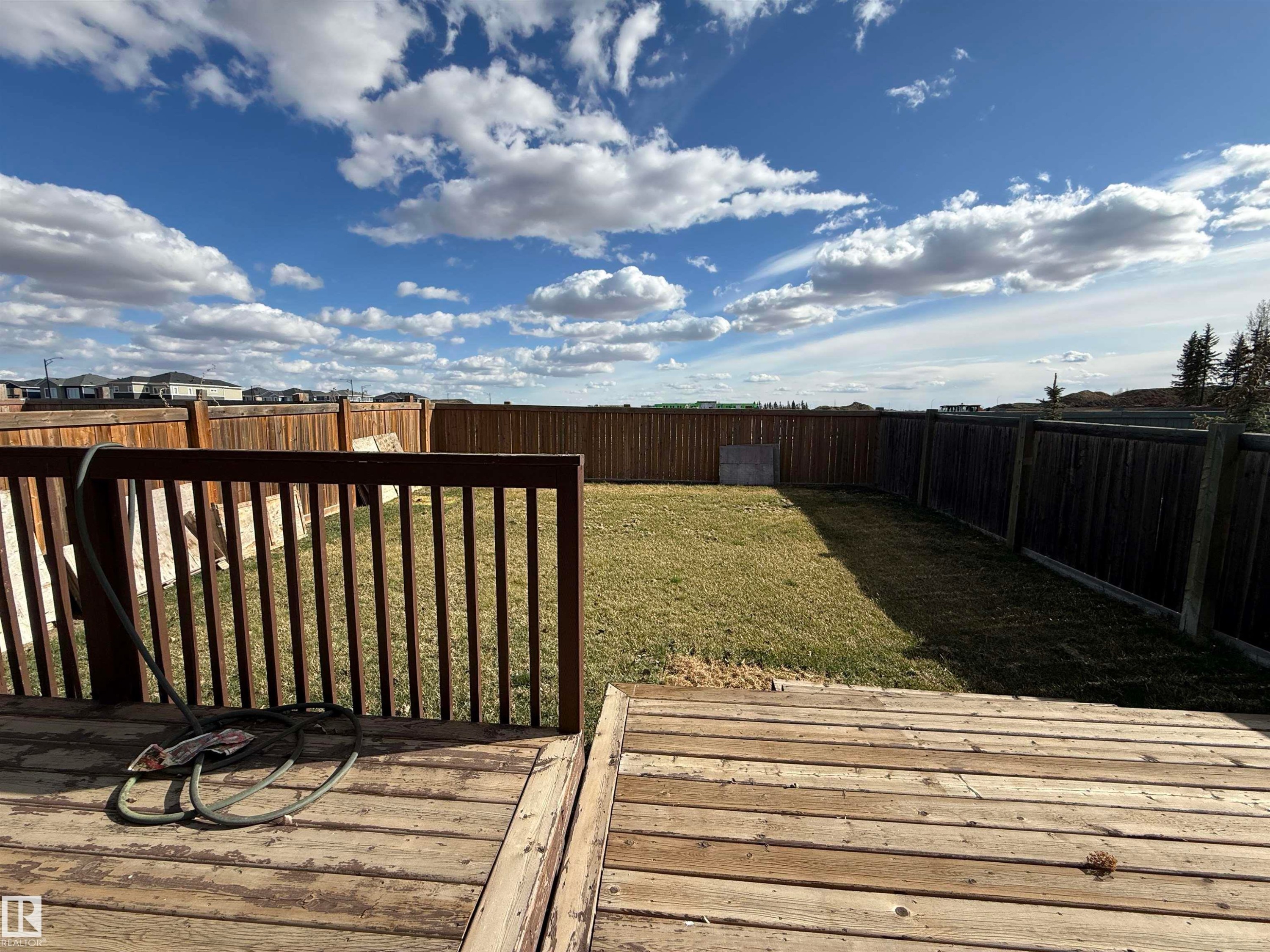 Wood-finish deck with railing overlooking a fenced backyard - 16627 18 Avenue, Edmonton, AB - Outdoor With View