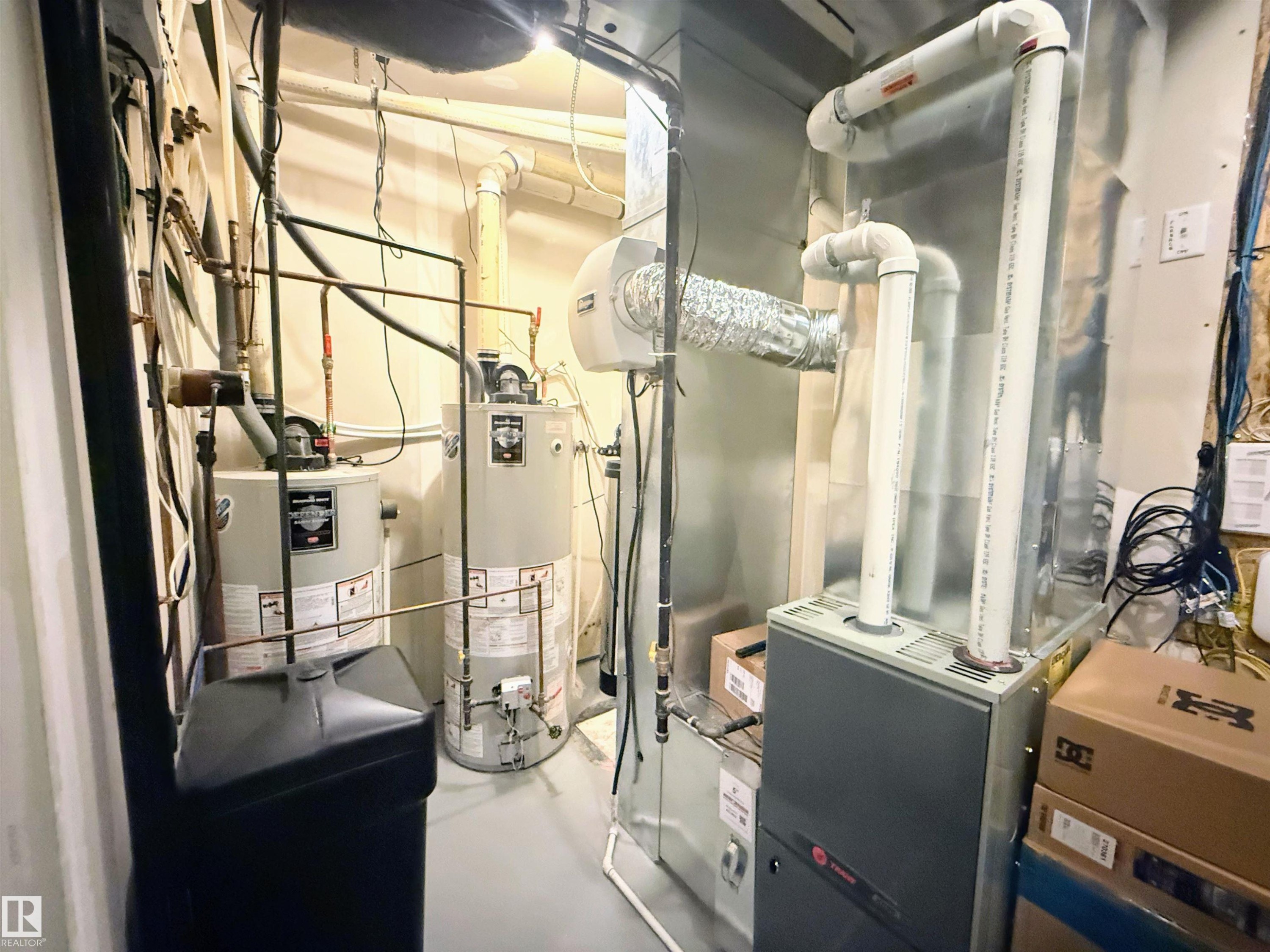 Utility room featuring two water heaters, a furnace, and visible ductwork - 3538 Claxton Crescent, Edmonton, AB - Indoor Photo Showing Basement