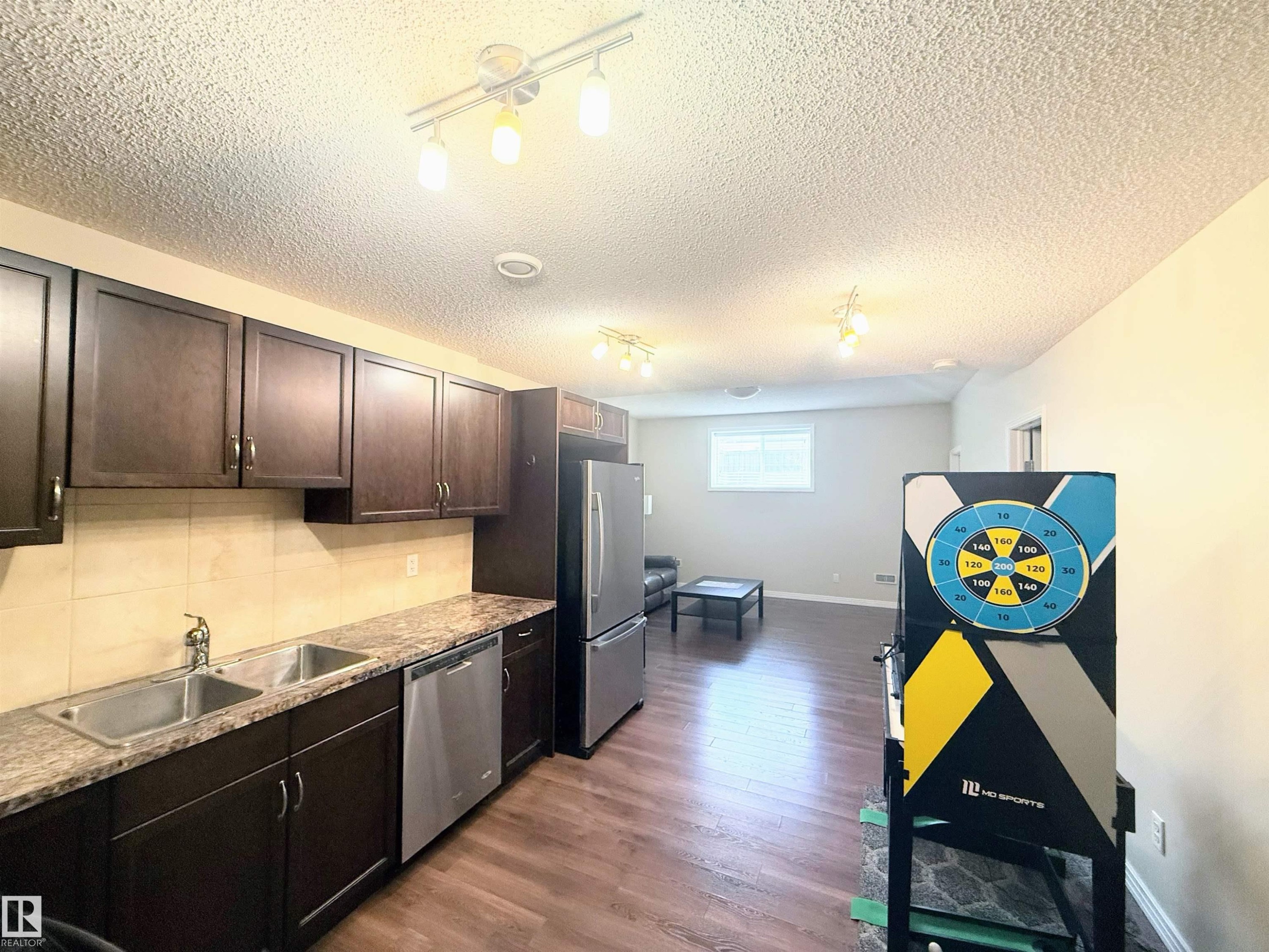Kitchenette featuring wood-finish cabinetry, speckled countertops, and stainless steel appliances - 3538 Claxton Crescent, Edmonton, AB - Indoor Photo Showing Kitchen With Stainless Steel Kitchen With Double Sink