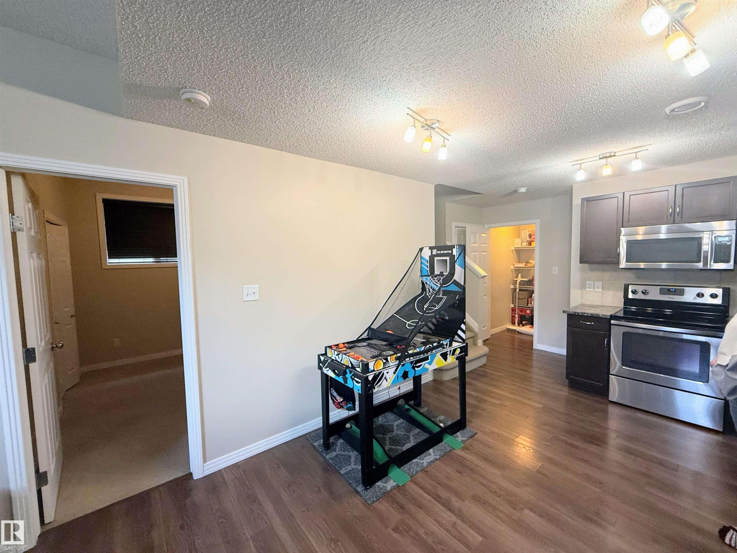 Kitchen featuring stainless steel appliances, dark cabinetry, and a light backsplash - 3538 Claxton Crescent, Edmonton, AB - Indoor Photo Showing Kitchen